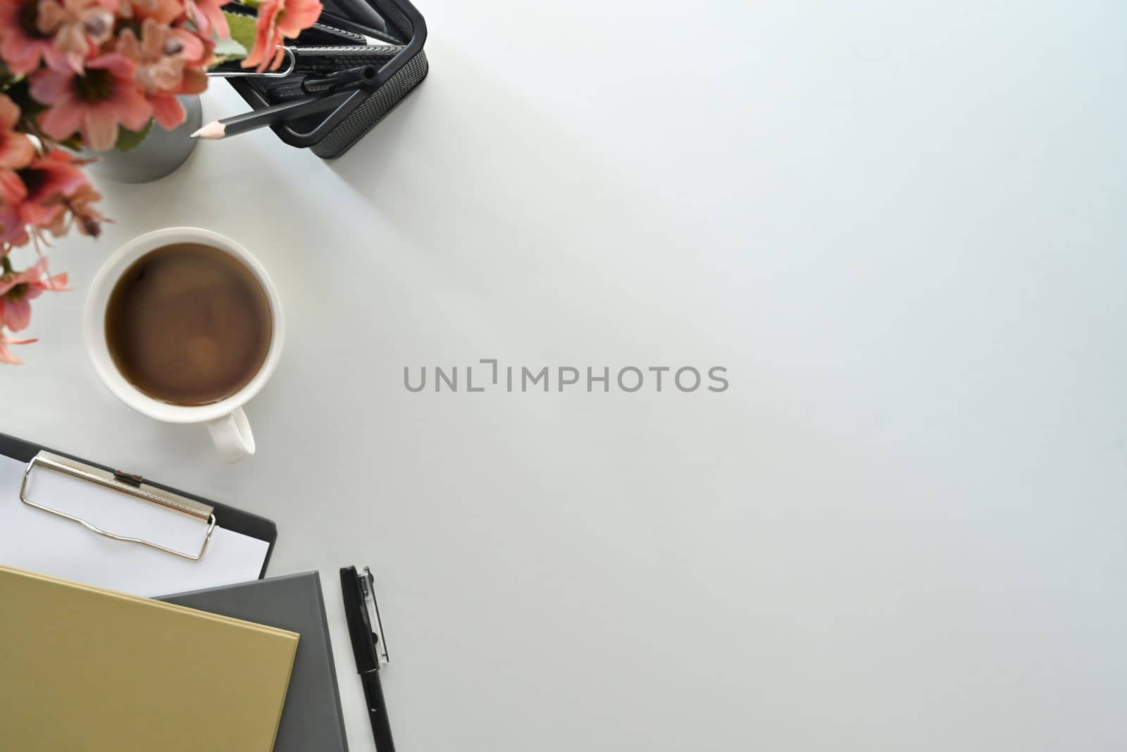 Simple workplace with notebooks, coffee cup and clipboard on white table Top view with copy space by prathanchorruangsak