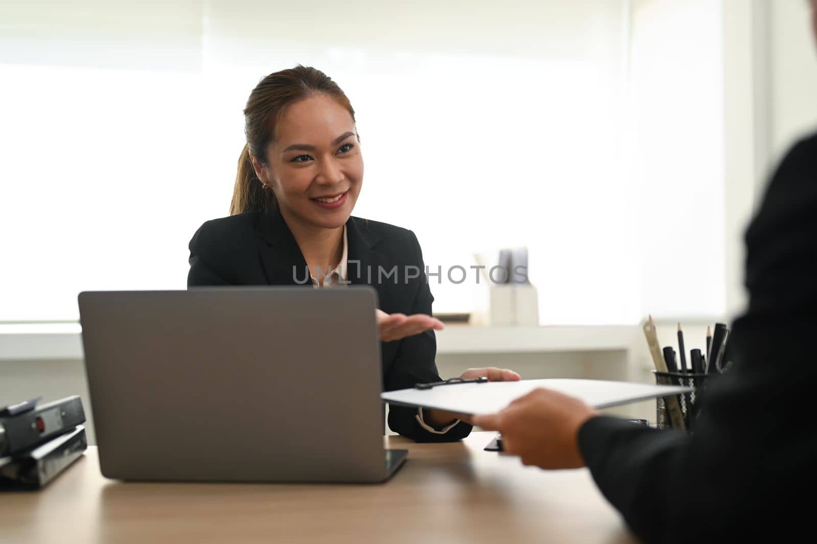 Friendly female HR manager talking negotiate with female job candidate at office meeting. Employment and recruitment concept.