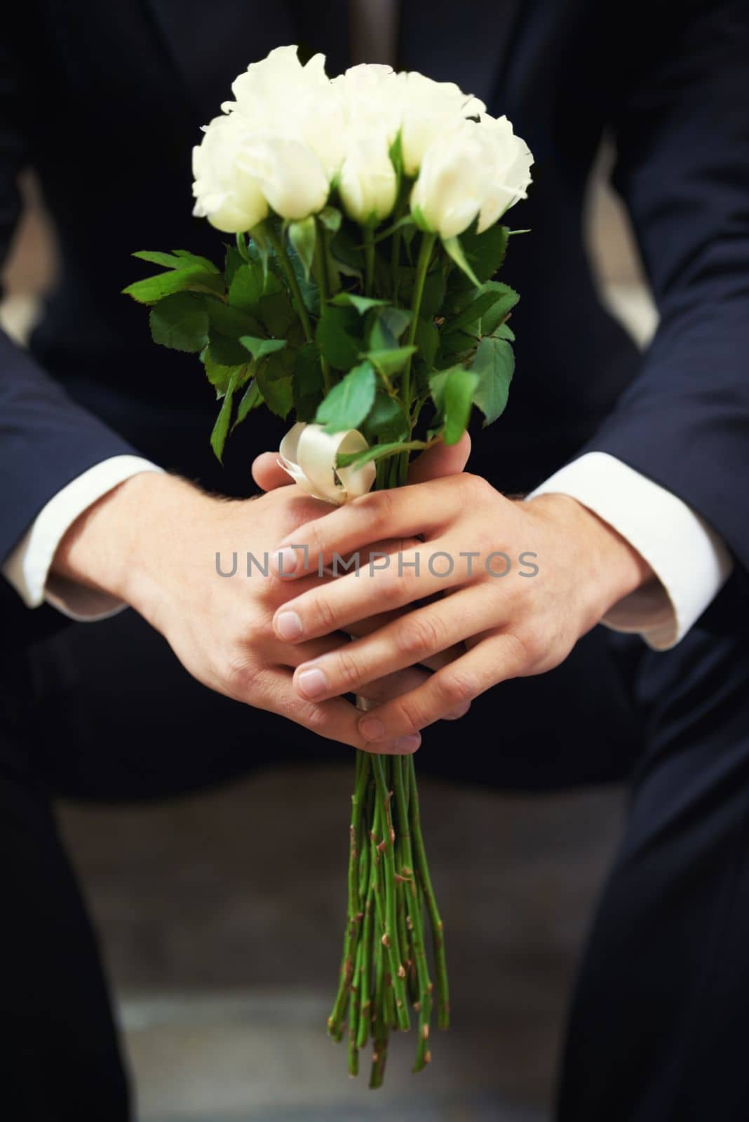 Hands, flowers and man on wedding day waiting for ceremony of love, tradition or romance closeup. Floral bouquet, marriage and commitment with a groom sitting outdoor alone at a celebration event.