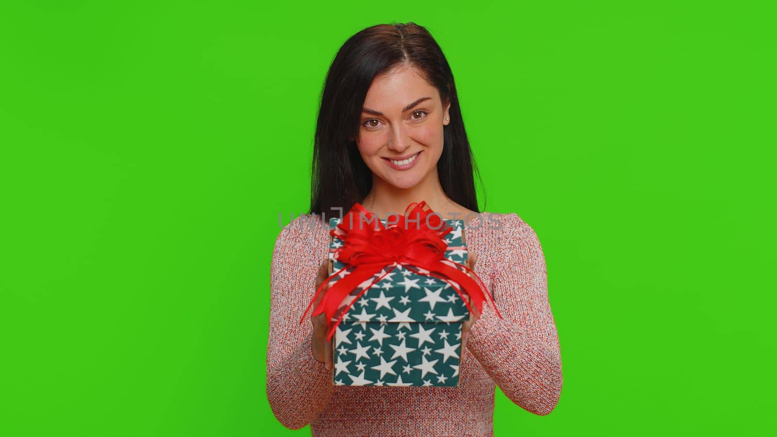 Positive smiling pretty woman presenting birthday gift box stretches out hands, offer wrapped present career bonus, celebrating party. Young adult happy girl isolated on green chroma key background