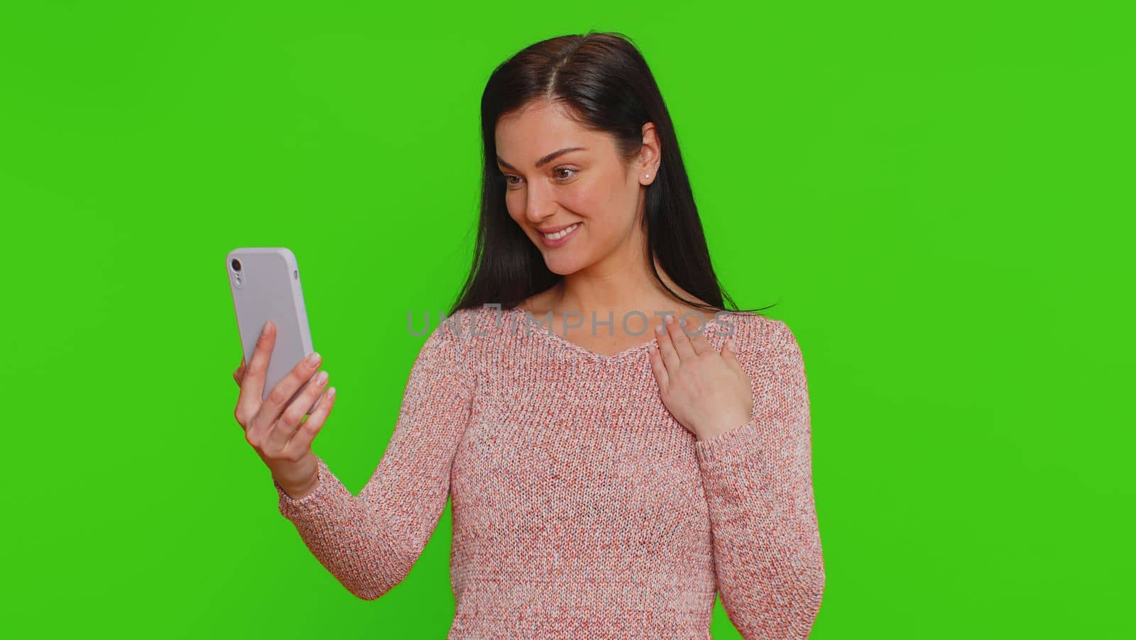 Pretty young woman influencer blogger taking selfie on smartphone, communicating video call online, recording new social media vlog story for subscribers. Girl isolated on chroma key background