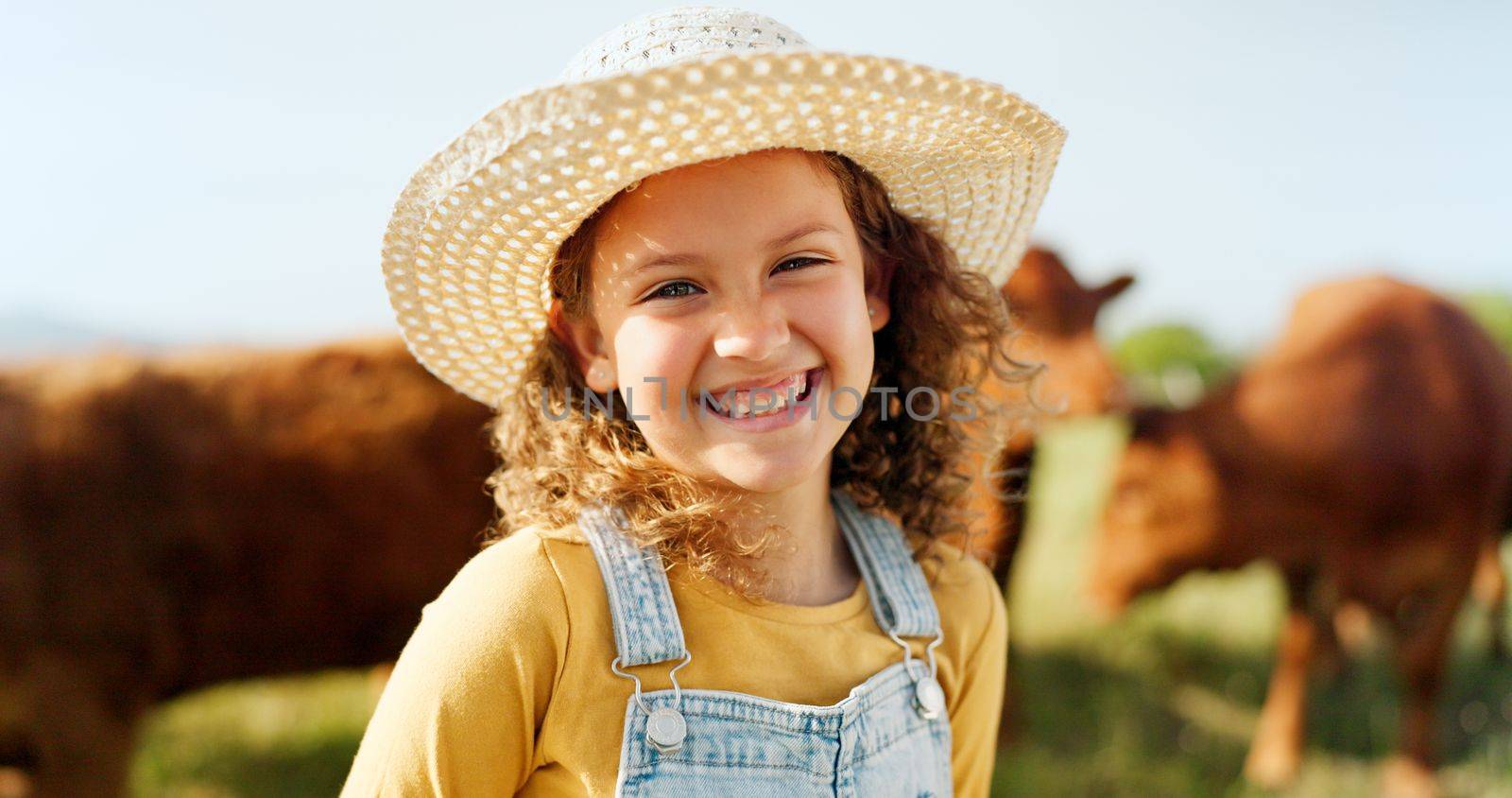 Happy little girl, portrait smile and farm with animals enjoying travel and nature in the countryside. Child smiling in happiness for agriculture, life and sustainability in farming and cattle.