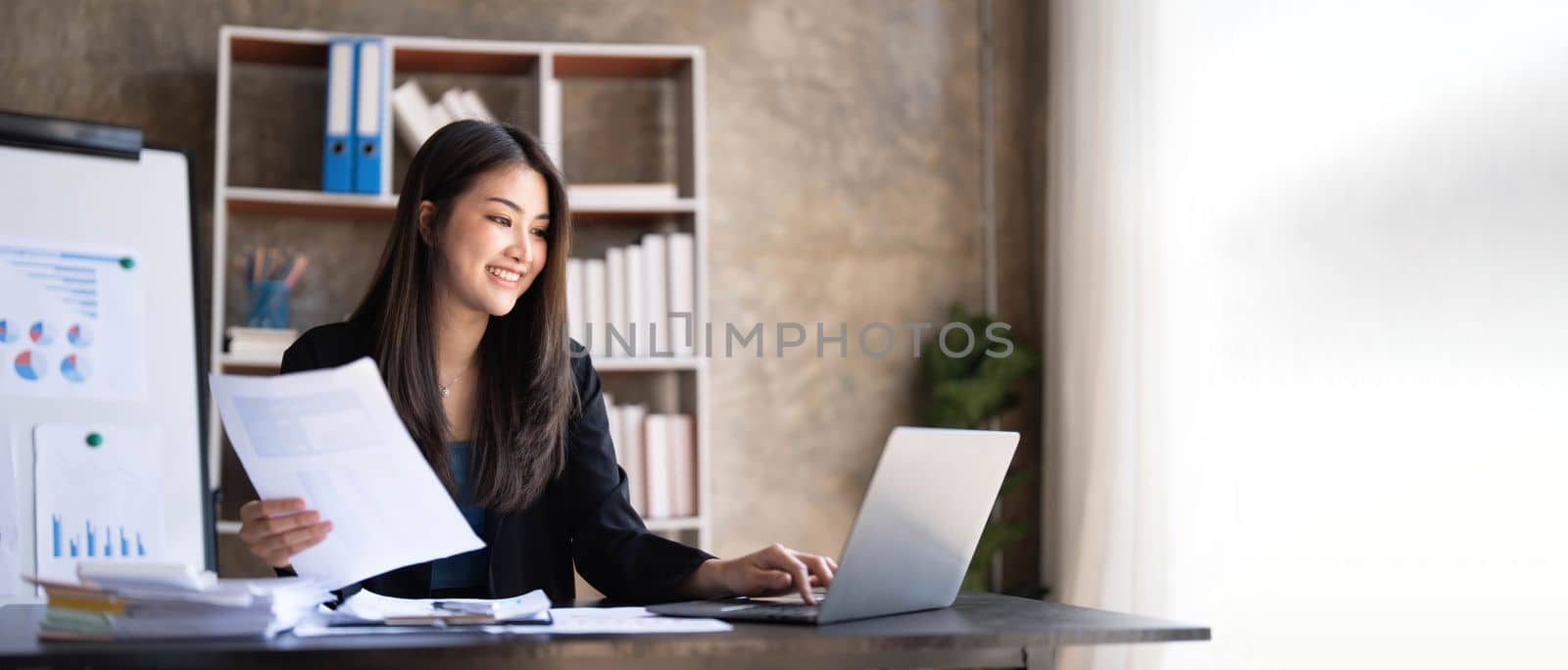 Business woman using calculator for do math finance on wooden desk in office and business working background, tax, accounting, statistics and analytic research concept. by wichayada