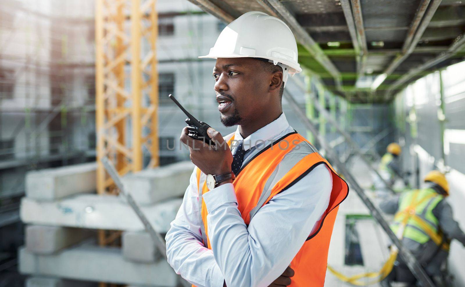Effective communication for better construction. a young man using a walkie talkie while working at a construction site