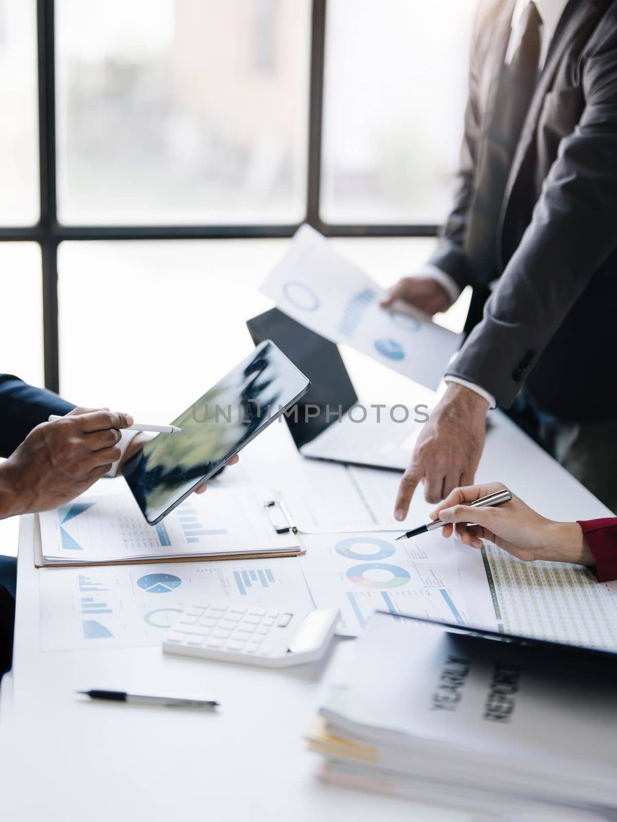 Business People Meeting using laptop computer,calculator,notebook,stock market chart paper for analysis Plans to improve quality next month. Conference Discussion Corporate Concept....