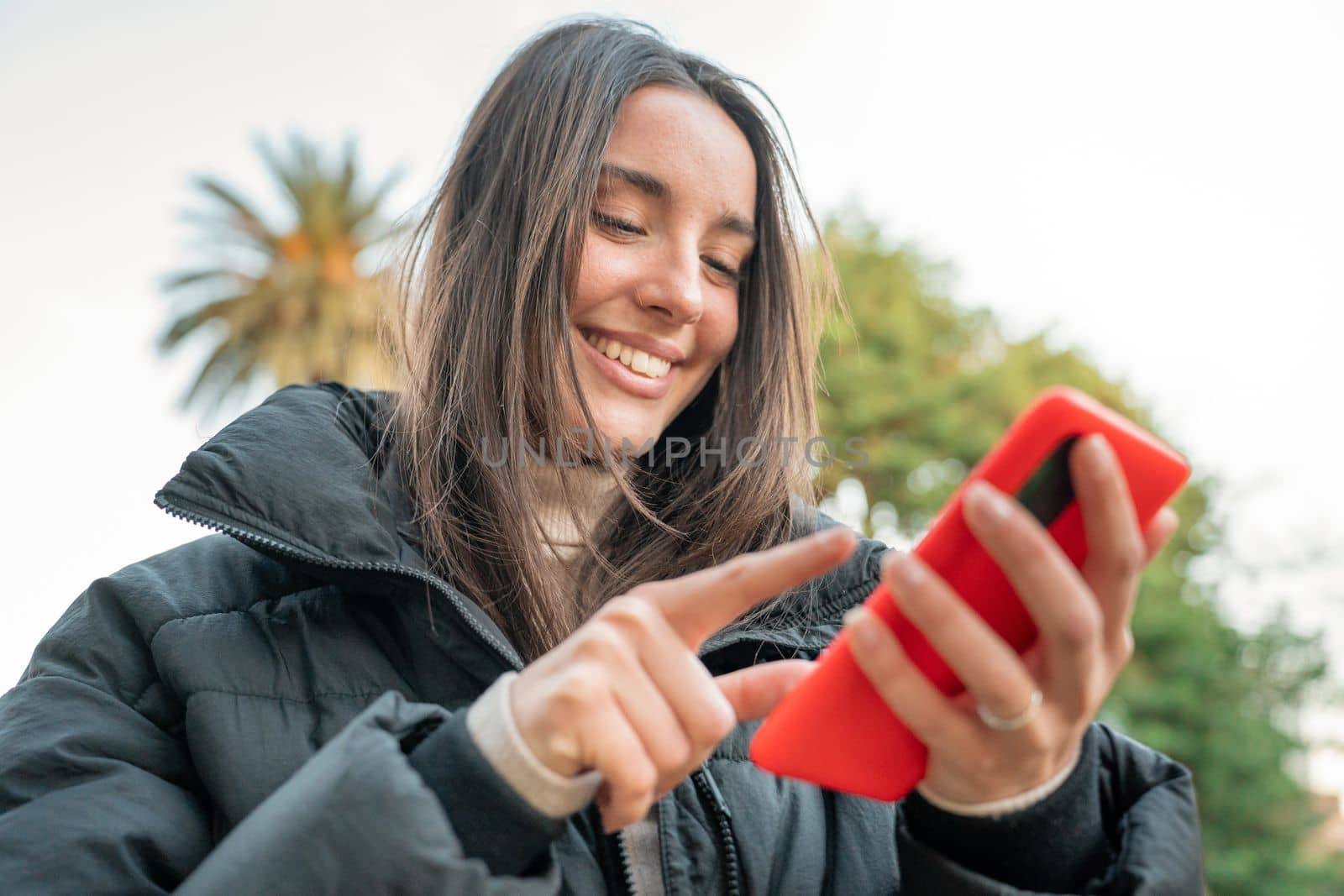 Influencer woman making a selfie blog outdoors in the park. Happy smiling lady taking video call. by PaulCarr