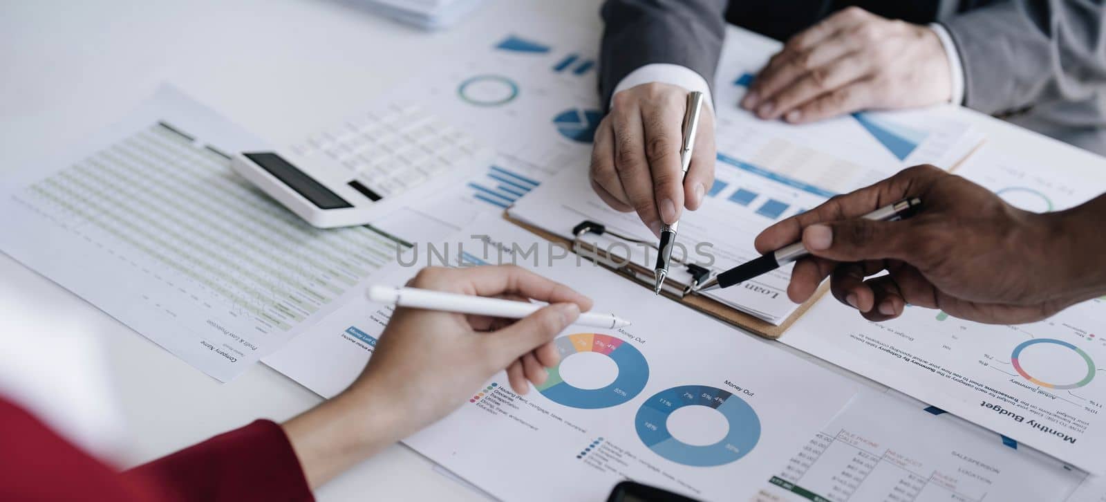 Business People Meeting using laptop computer,calculator,notebook,stock market chart paper for analysis Plans to improve quality next month. Conference Discussion Corporate Concept. by wichayada