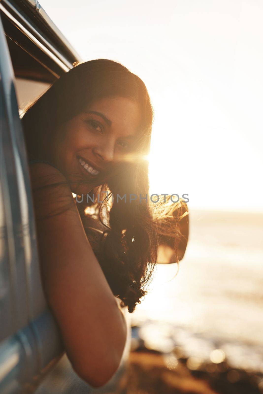 Travel at least once a year. an attractive young woman enjoying a road trip. by YuriArcurs