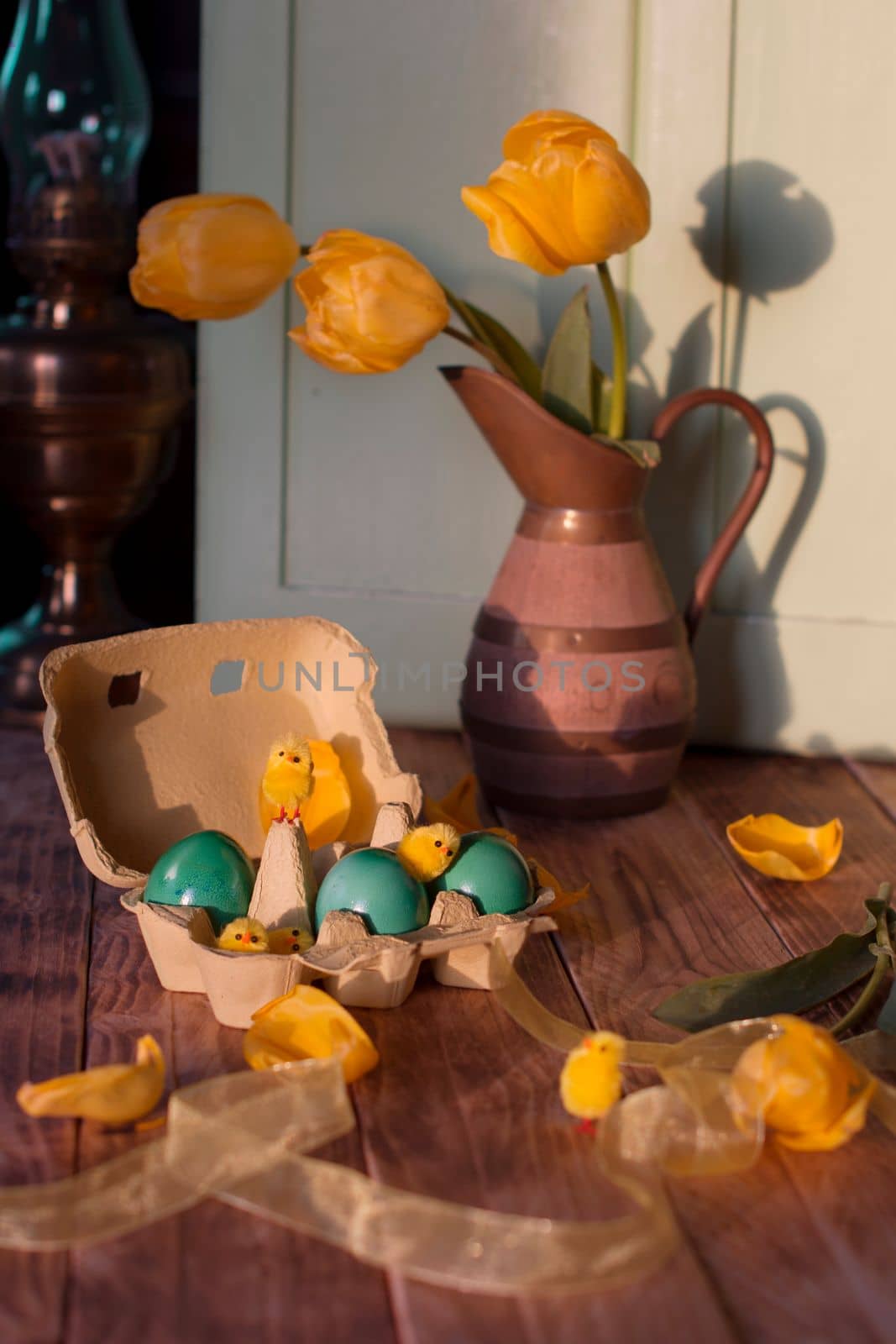 Easter still life with yellow tulips, green eggs and small chickens. High quality photo