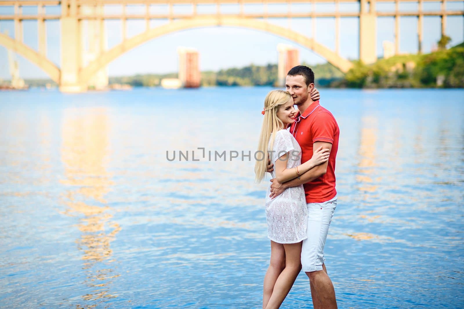 couple in love blonde girl and guy on the river bank by Andreua