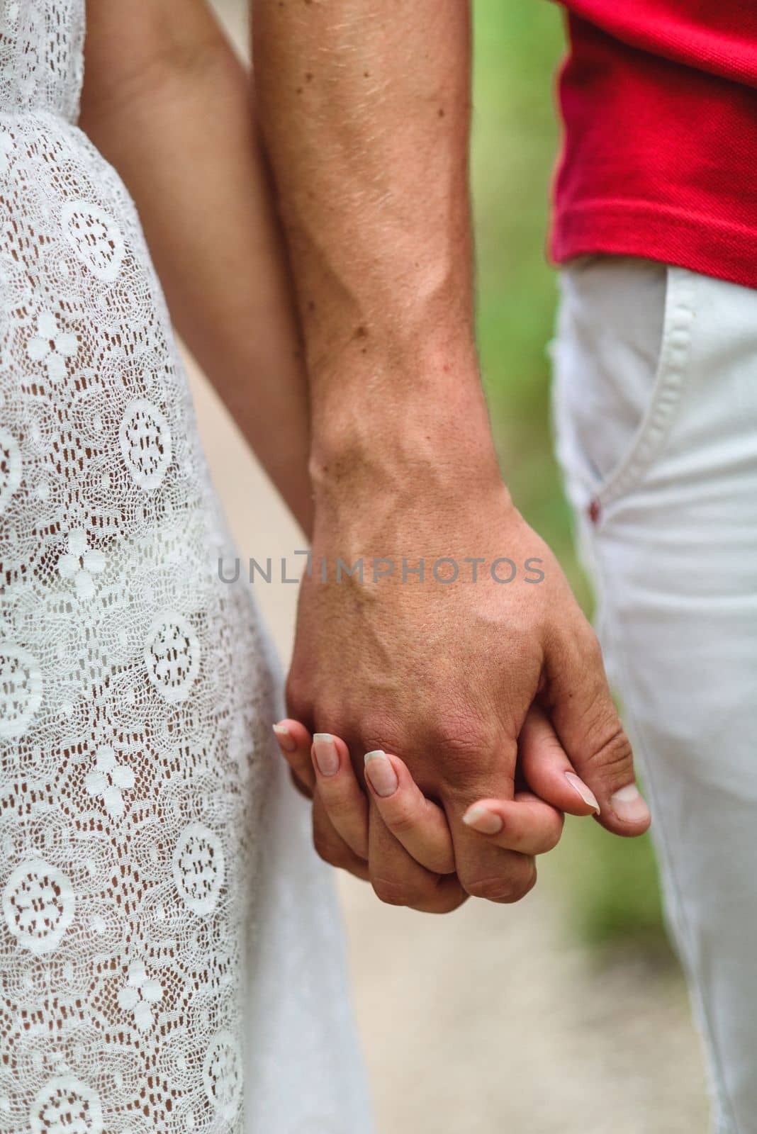 couple in love a blonde girl and a guy in a red t-shirt at a picnic in a park with green grass