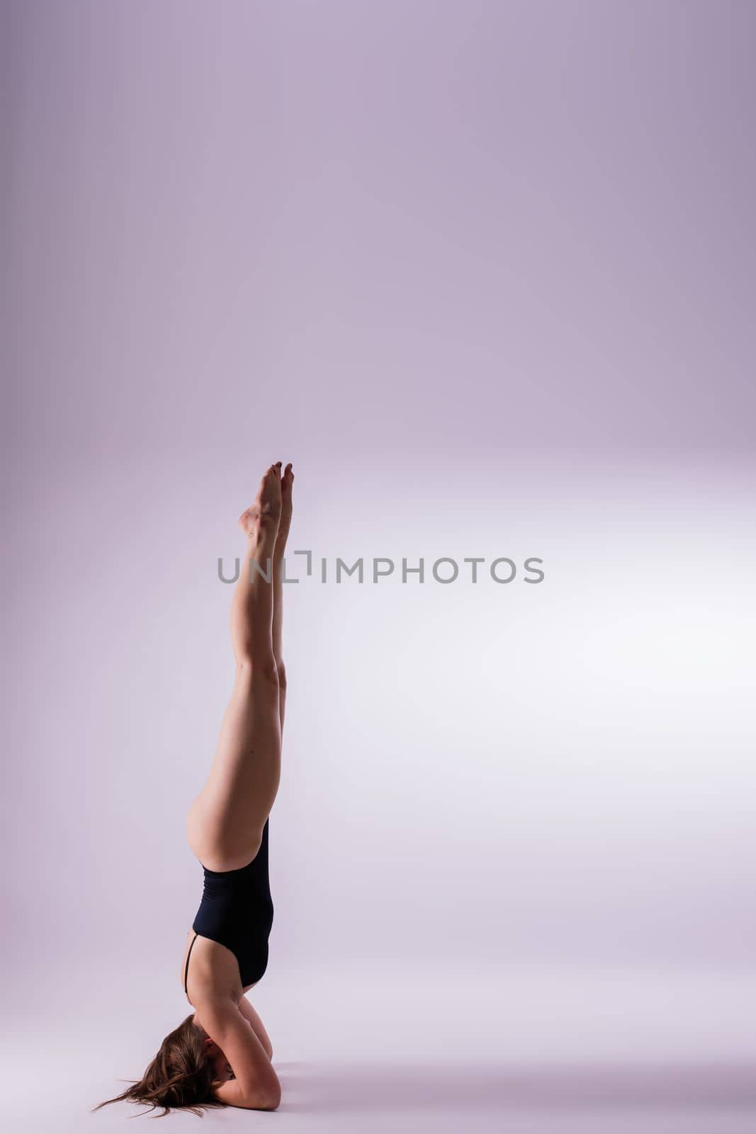 Portrait of beautiful young woman wearing black sportswear working out in studio. Full length. by Zelenin