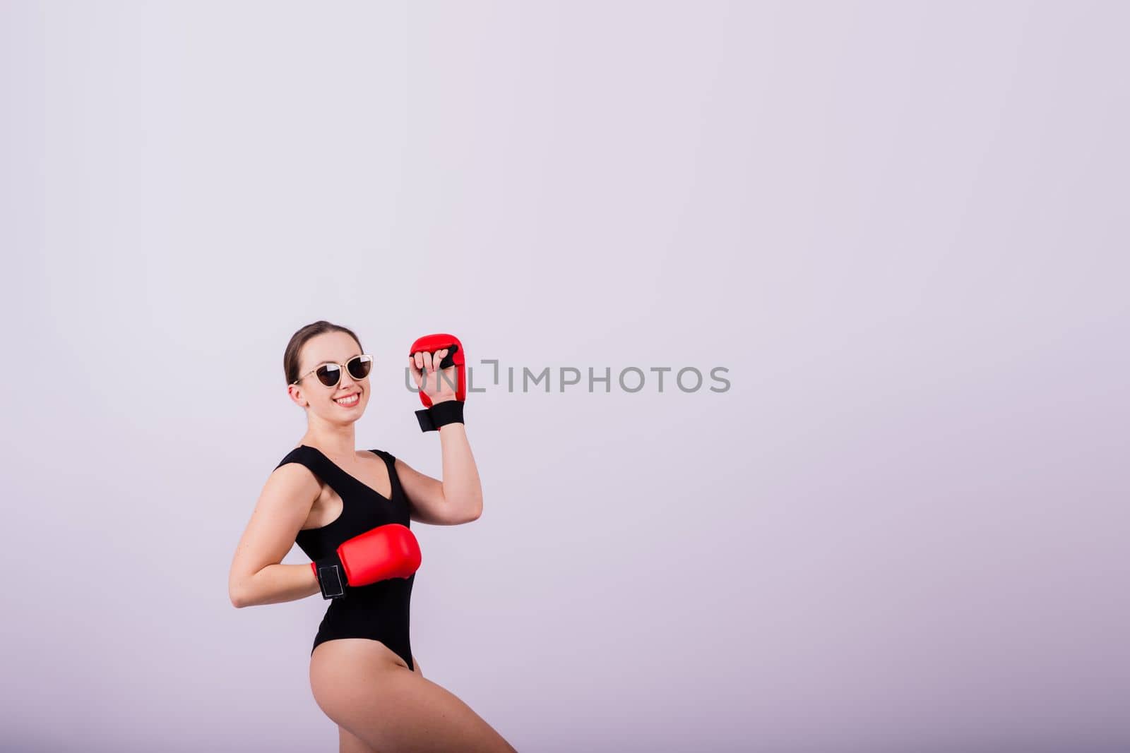 Studio portrait of a boxer female in bodysuit with gloves red