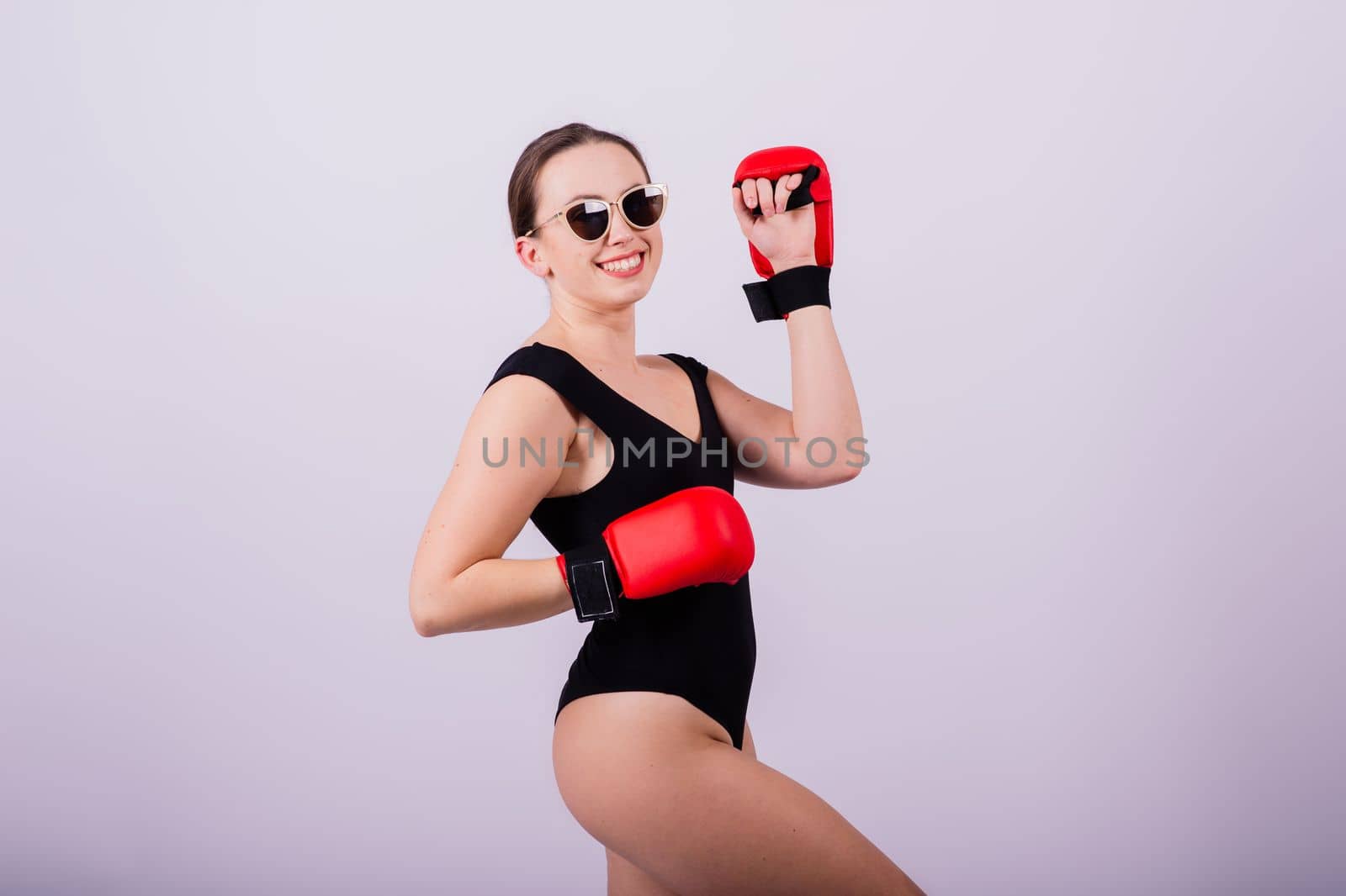 Studio portrait of a boxer female in bodysuit with gloves by Zelenin
