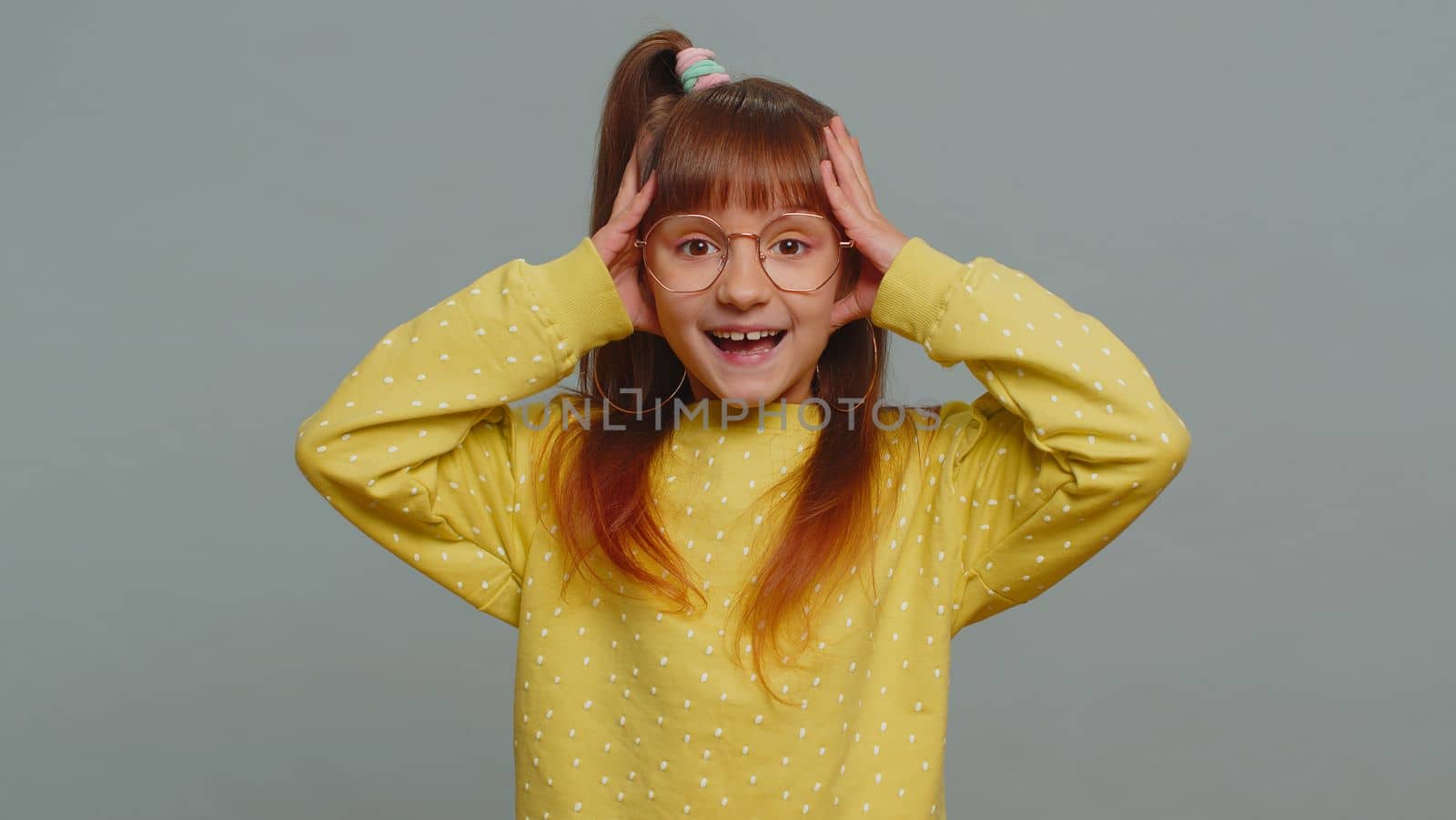 Oh my God, Wow. Young preteen child girl kid looking surprised at camera with big eyes, shocked by sudden victory, game winning lottery goal achievemen good news. Toddler children on gray background