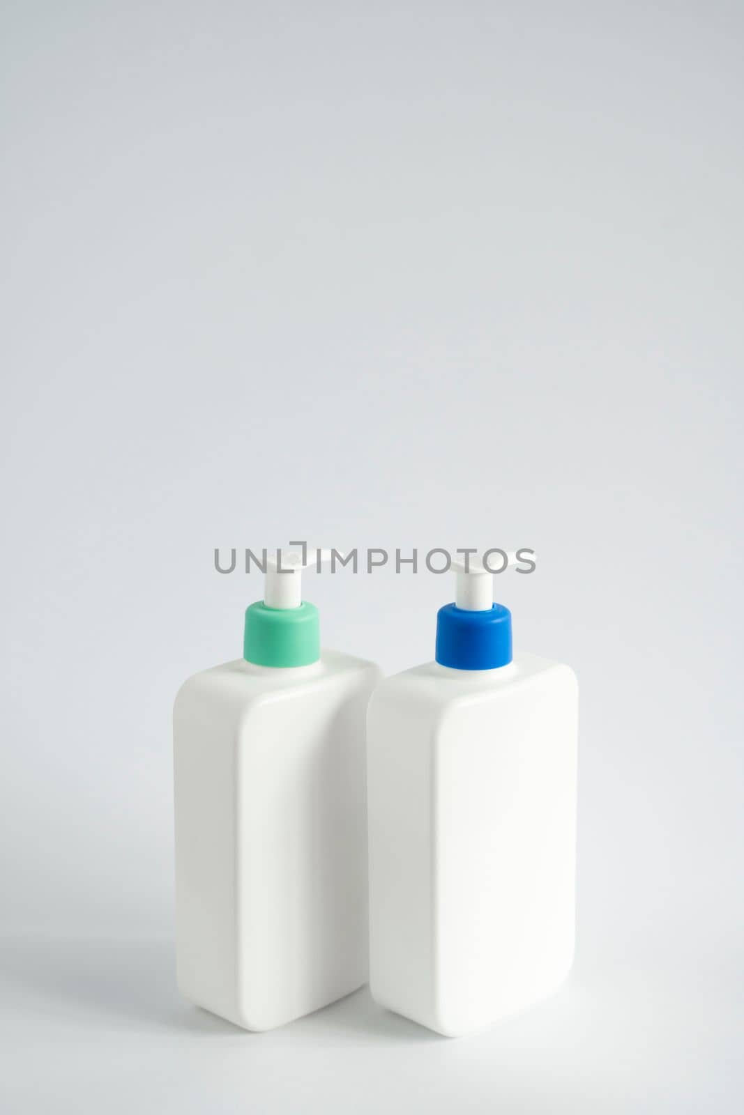 White blank plastic bottles with dispenser pump for gel, liquid soap, lotion, cream, shampoo on white background. Cosmetics