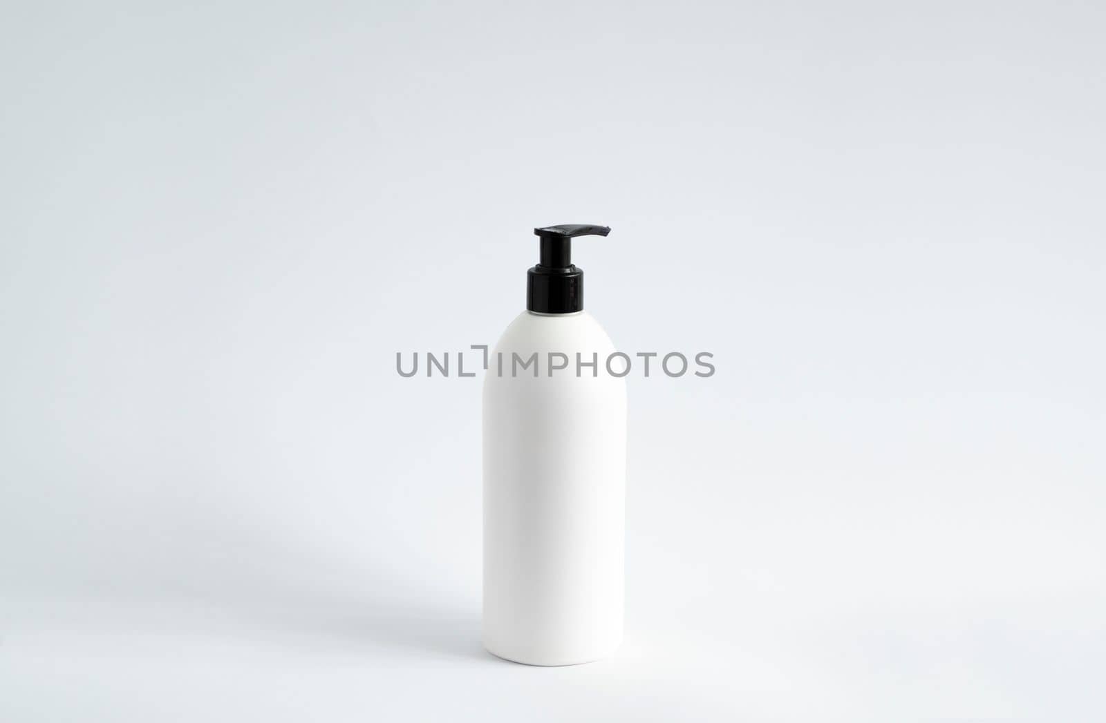 White blank plastic bottle with black dispenser pump for gel, liquid soap, lotion, cream, shampoo on white background. Cosmetics
