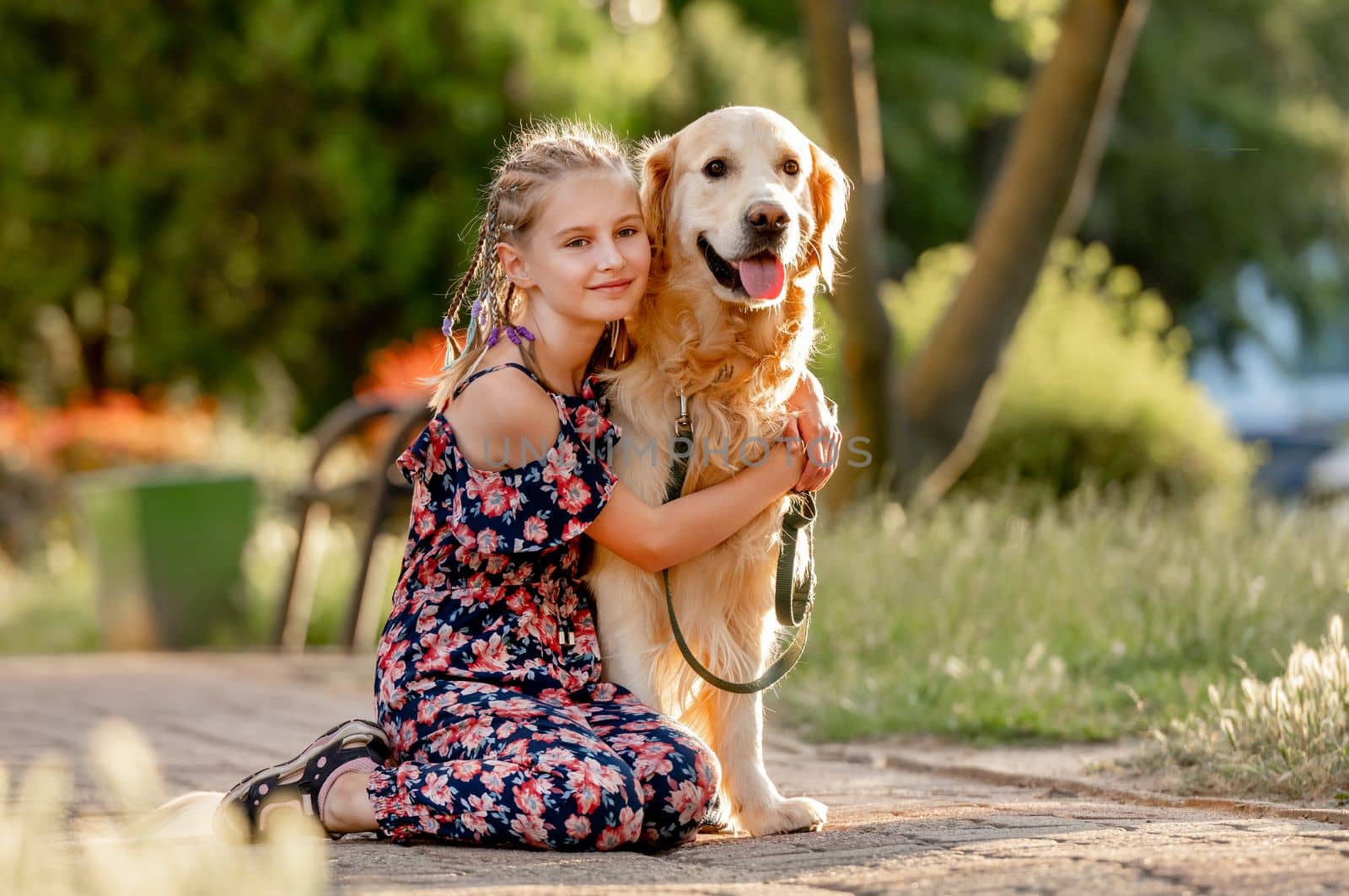 Preteen girl and her golden retriever dog on lace looking at camera. Female child kid with a purebred labrador doggy pet