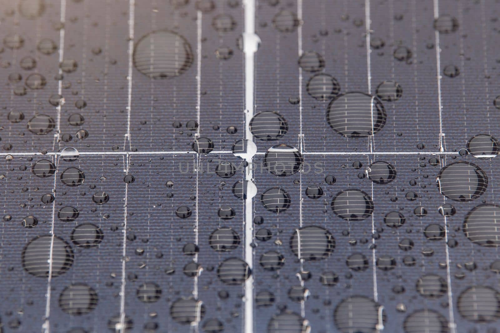 Green energy. Solar panels with raindrops close up. The use of waterproof solar panels in difficult environments, the production of green energy