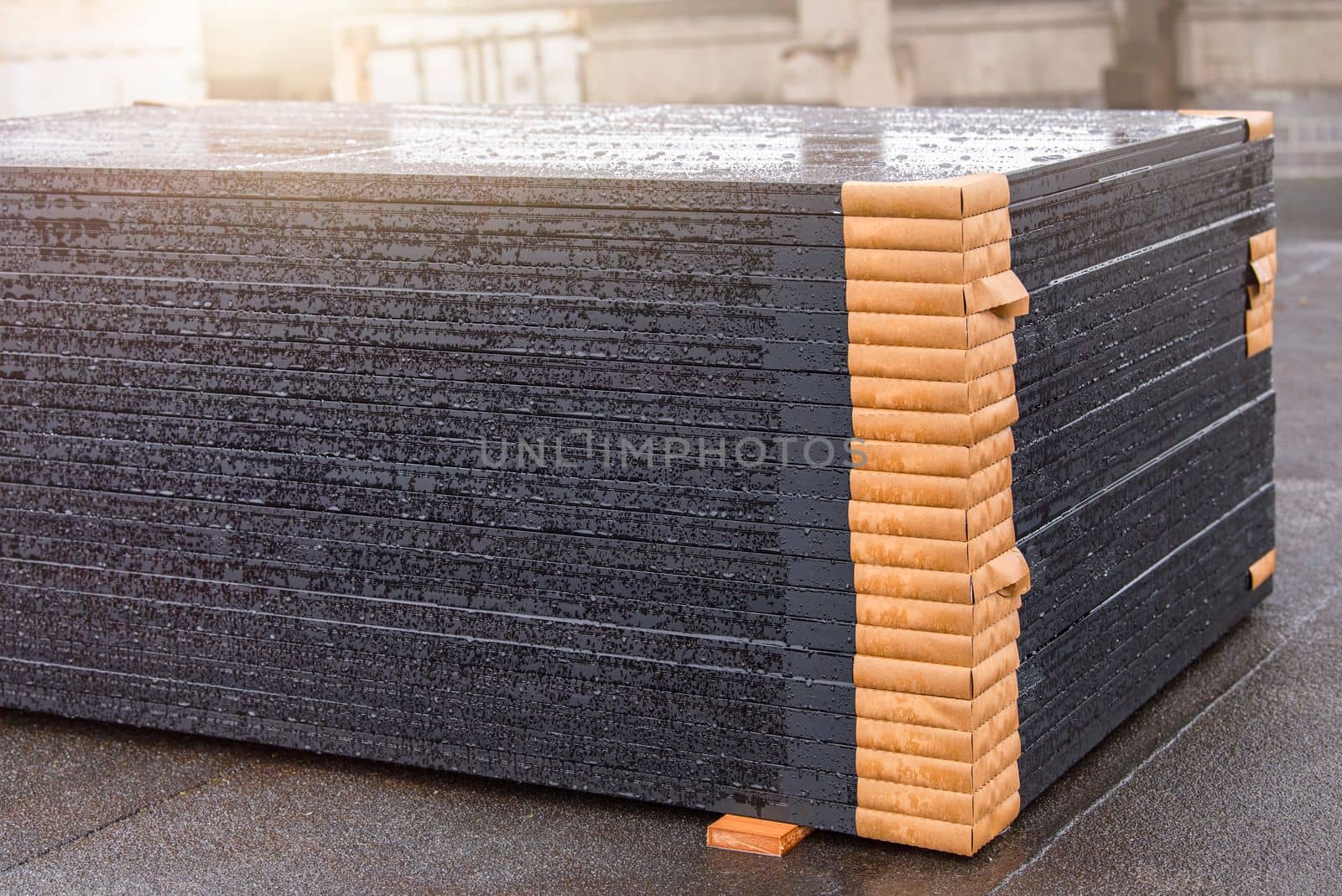 Green energy. Modules of solar panels for the production of renewable energy, lie on the roof of the building before installation, installation of solar panels