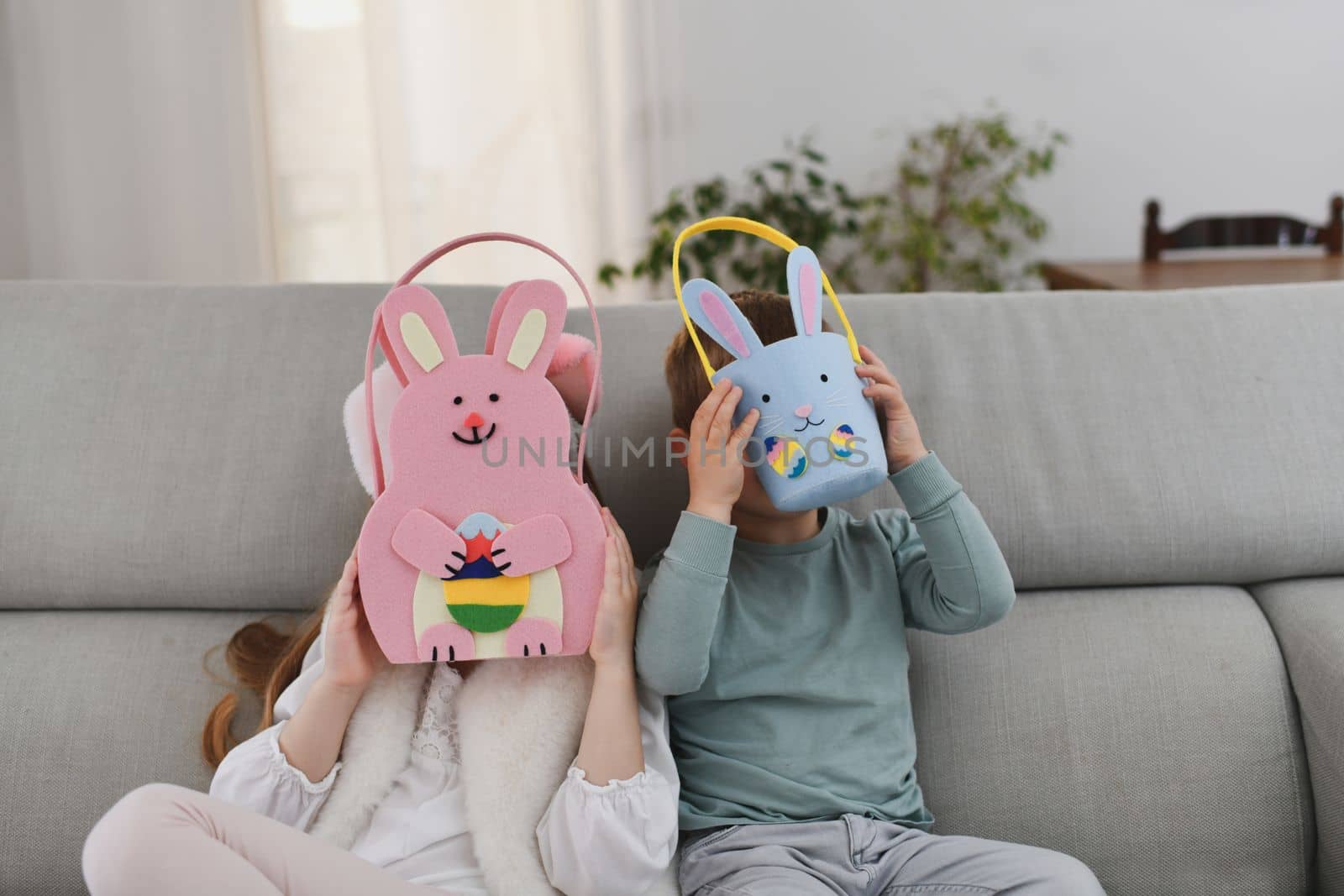The kids with bunny ears and basket for chocolate eggs