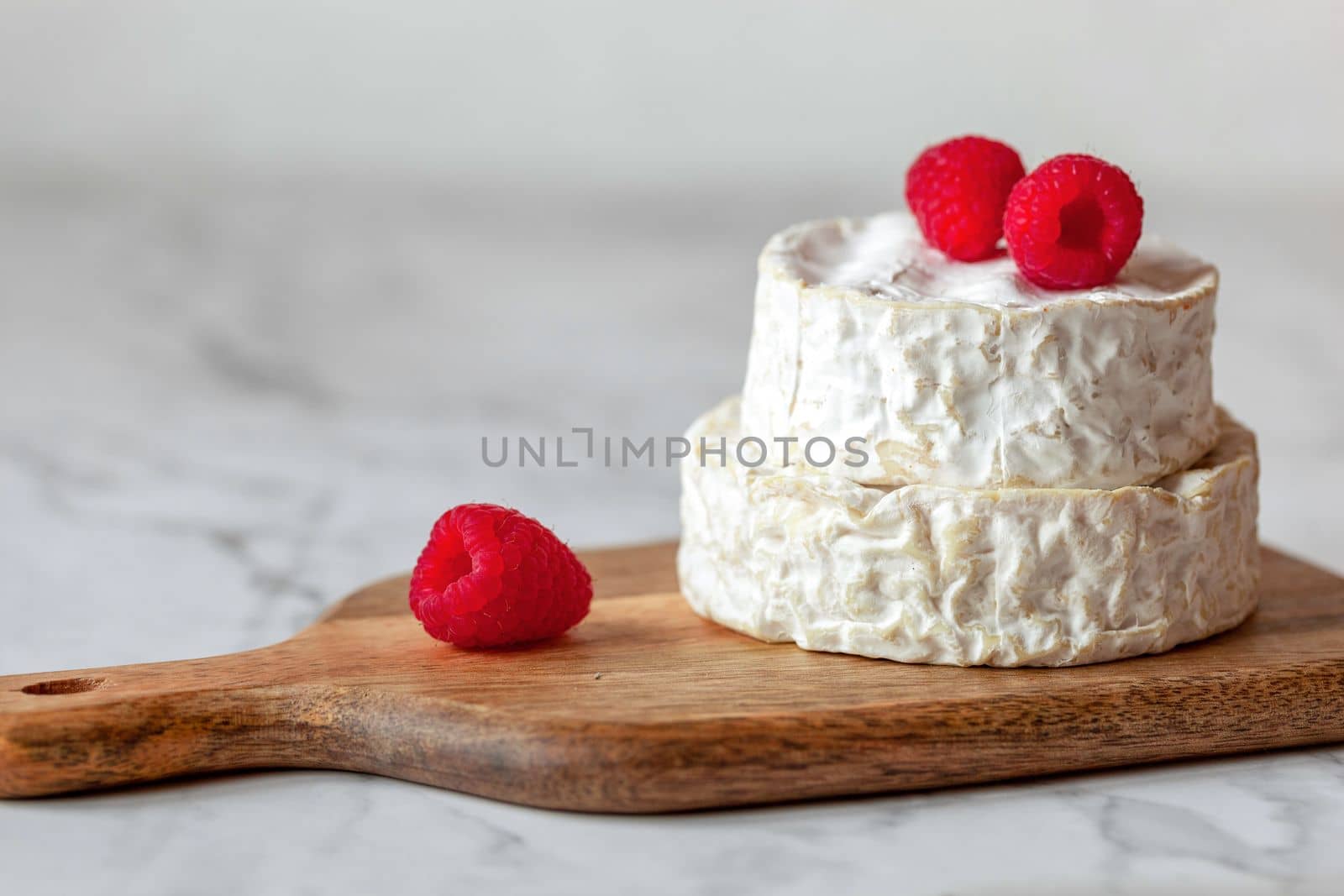 camembert french soft cheese served with raspberries, minimalism