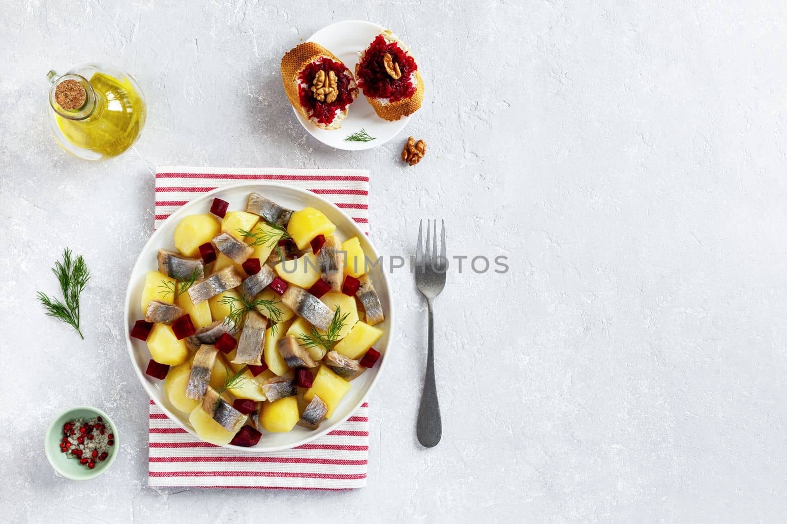 smoked hering, potato and beetroot salad served with beetroot caviar toasts, top view, copy space