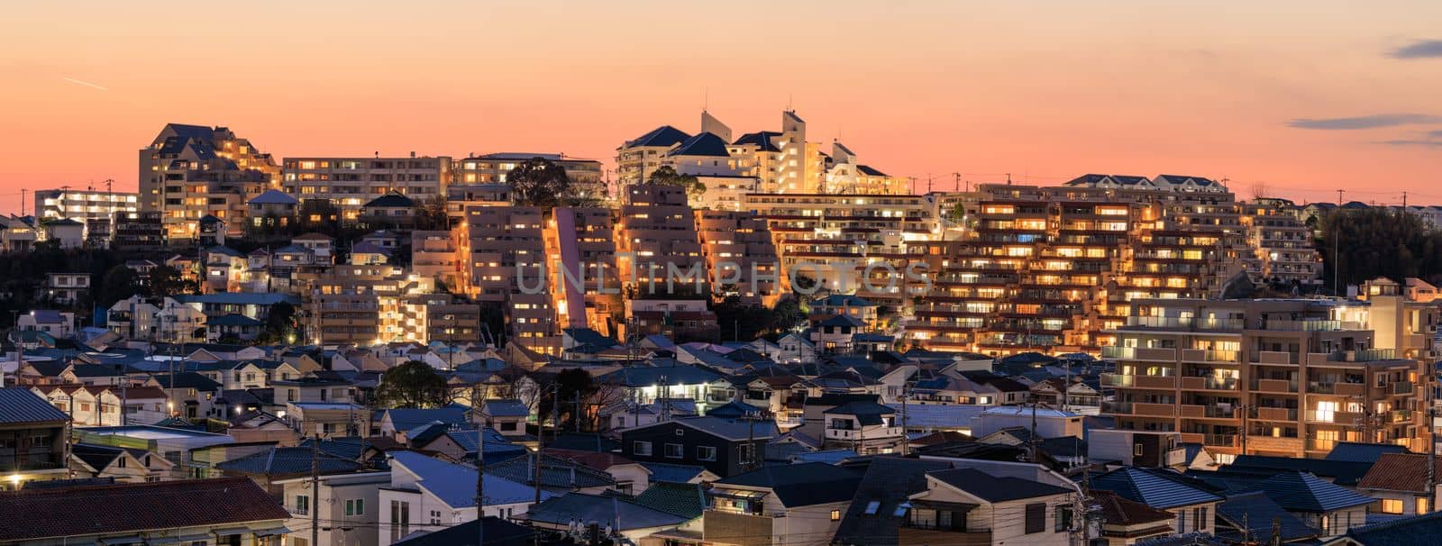 Sunset glow over lights from apartments and houses in residential neighborhood. High quality photo