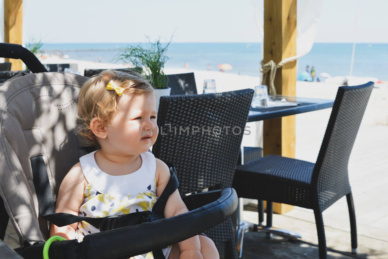 Girl child in a stroller in a restaurant