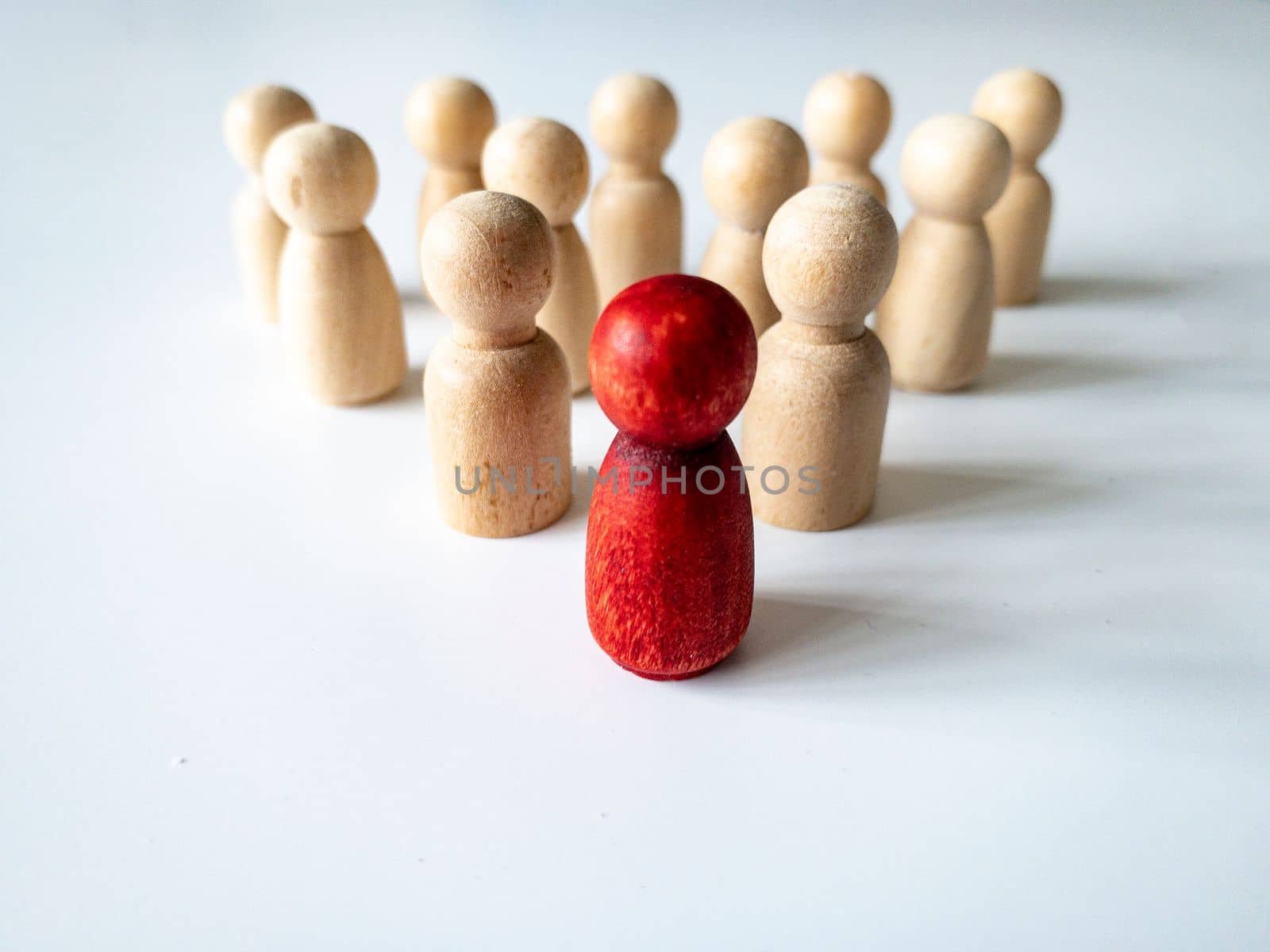 Red wooden doll leading the rest of wooden figure. Leadership and followers concept. Copy space