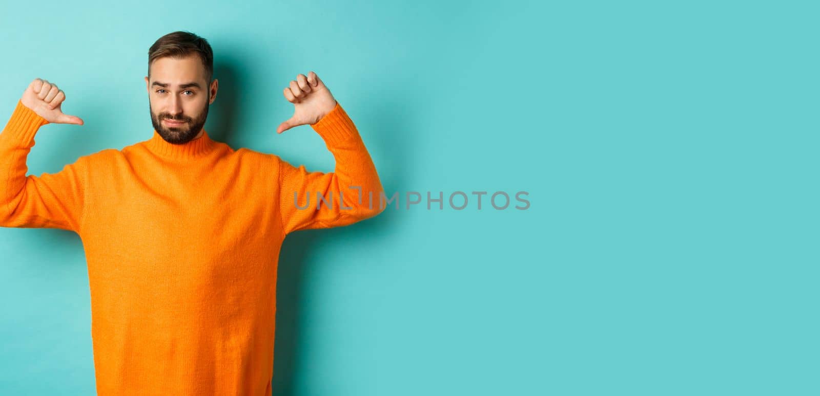 Confident attractive guy pointing at himself, show-off or brag, standing over light blue background by Benzoix