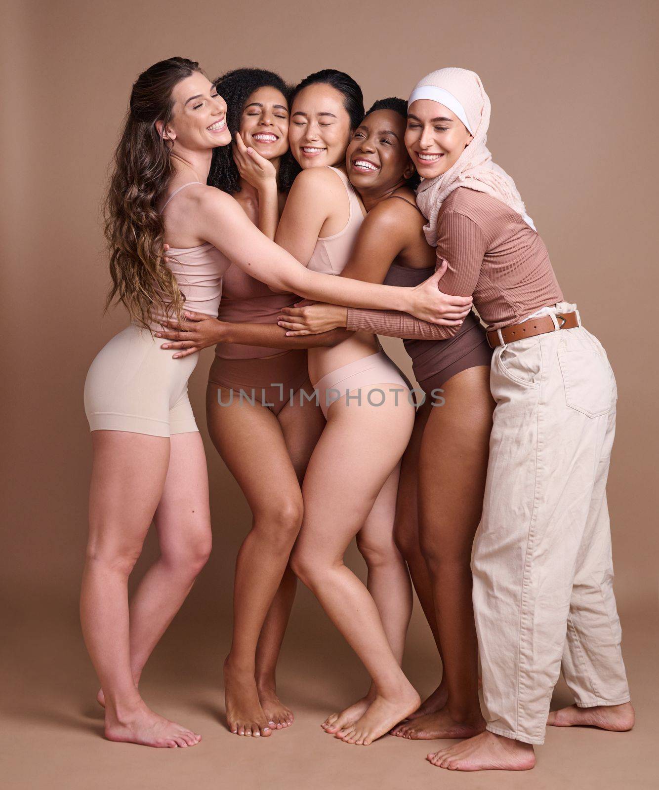 Diversity hug, beauty and body positive women in studio on a brown background. Underwear, skincare and group of different, young or happy female models in makeup with eyes closed posing for self love by YuriArcurs