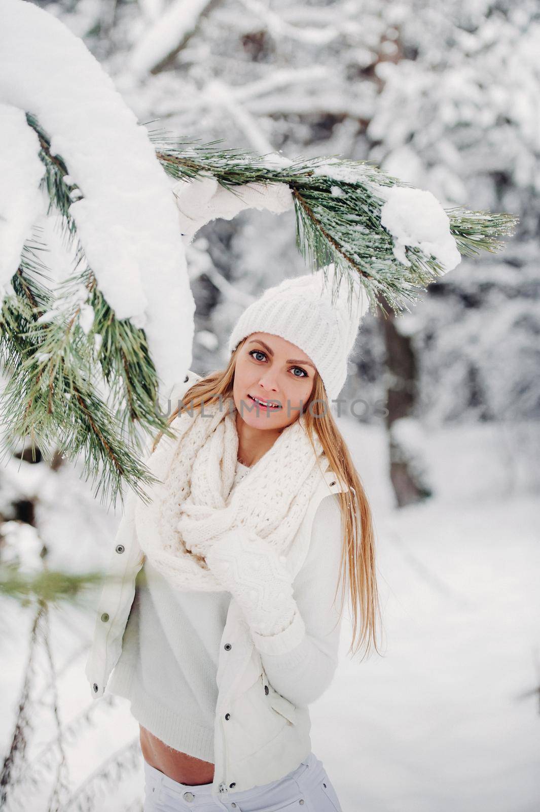 Portrait of a woman in white clothes in a cold winter forest. A girl with a white hat on her head in a snow-covered winter forest by Lobachad