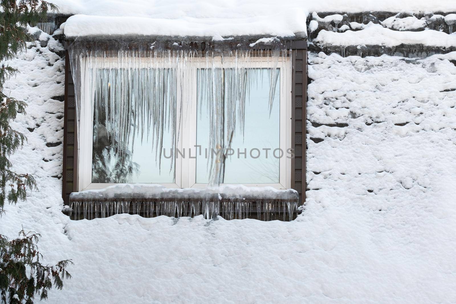 Icicles on the window of the house on a frosty day..