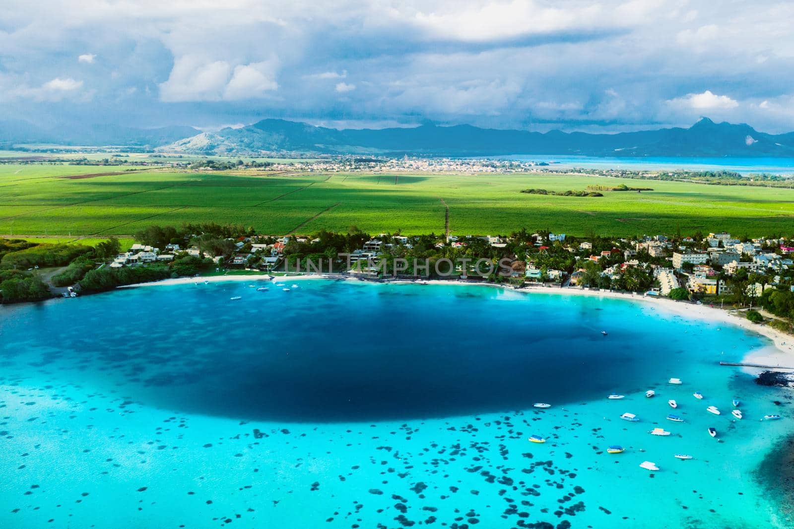 Aerial picture of the east coast of Mauritius Island. Beautiful lagoon of Mauritius Island shot from above. Boat sailing in turquoise lagoon by Lobachad