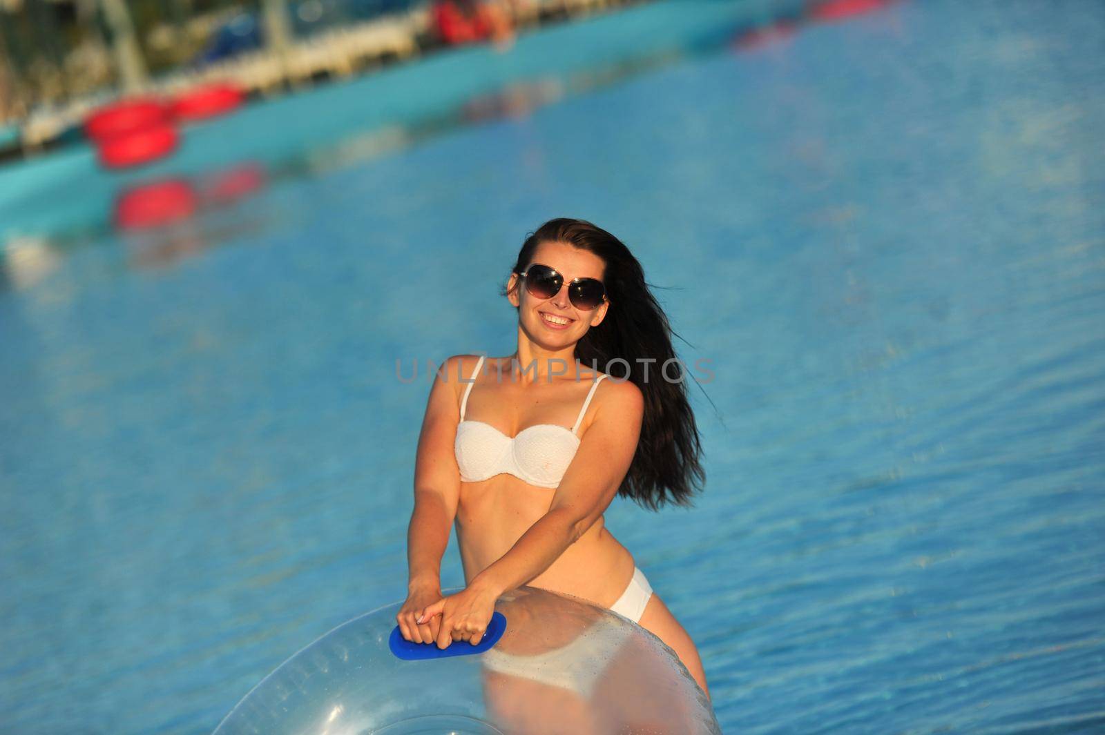 A woman in a white bathing suit with an inflatable circle in a water Park.