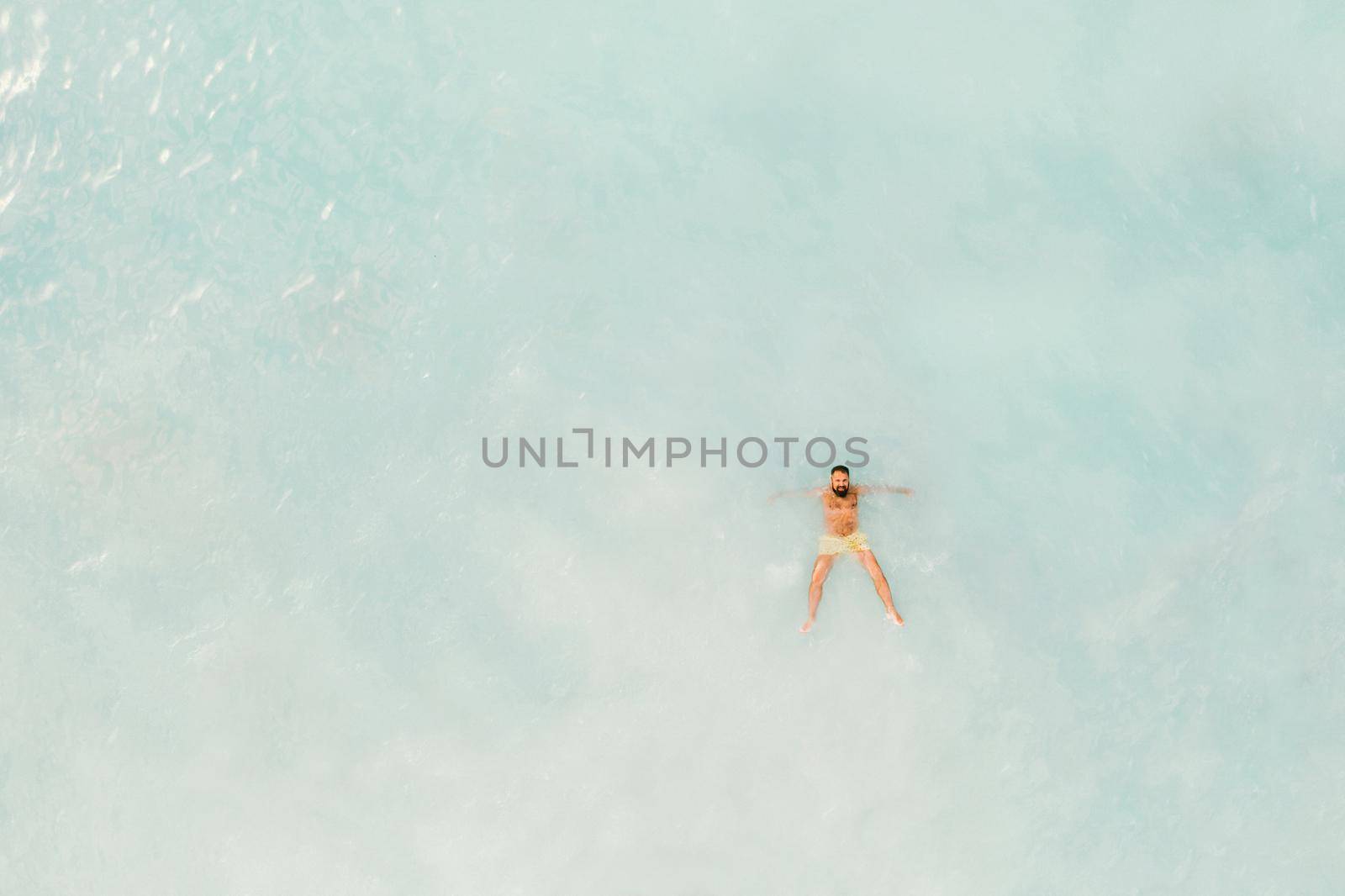 The view from the bird's eye view of the ocean, filled with people on a hot Sunny day.People swim in the Indian ocean on the island of Mauritius by Lobachad