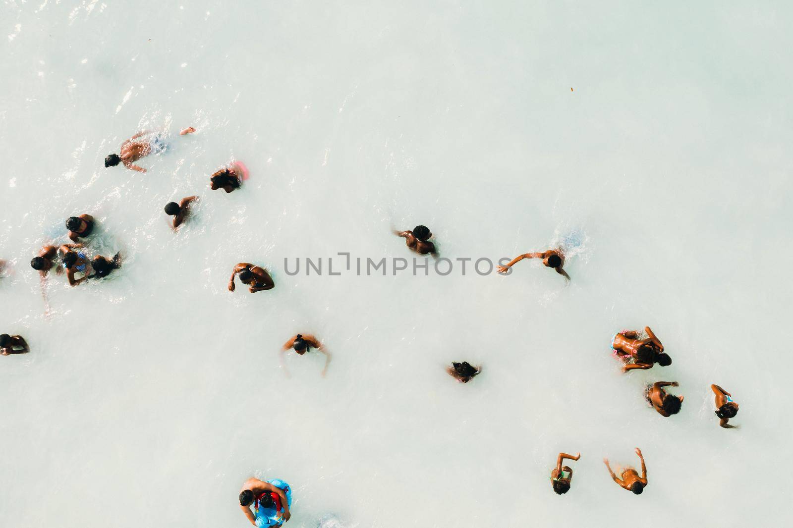 The view from the bird's eye view of the ocean, filled with people on a hot Sunny day.People swim in the Indian ocean on the island of Mauritius by Lobachad