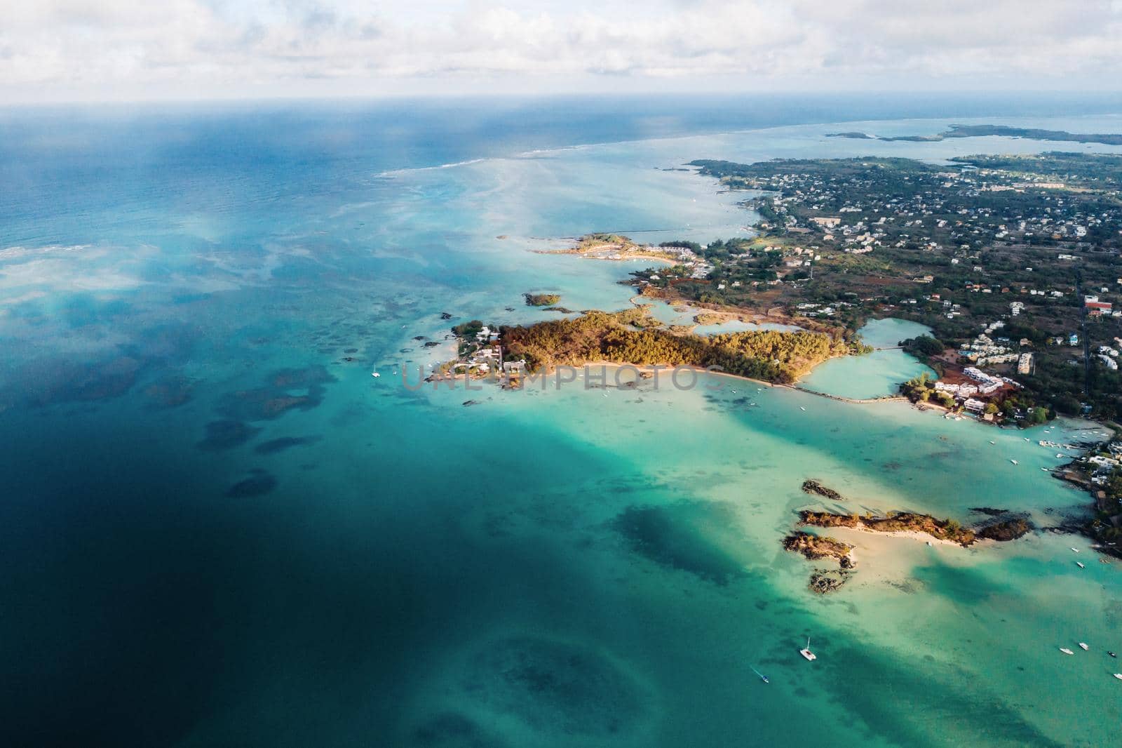 Aerial picture of the north, north east coast of Mauritius Island. Beautiful lagoon of Mauritius Island shot from above. Two catamaran boat and a speed boat sailing in turquoise lagoon