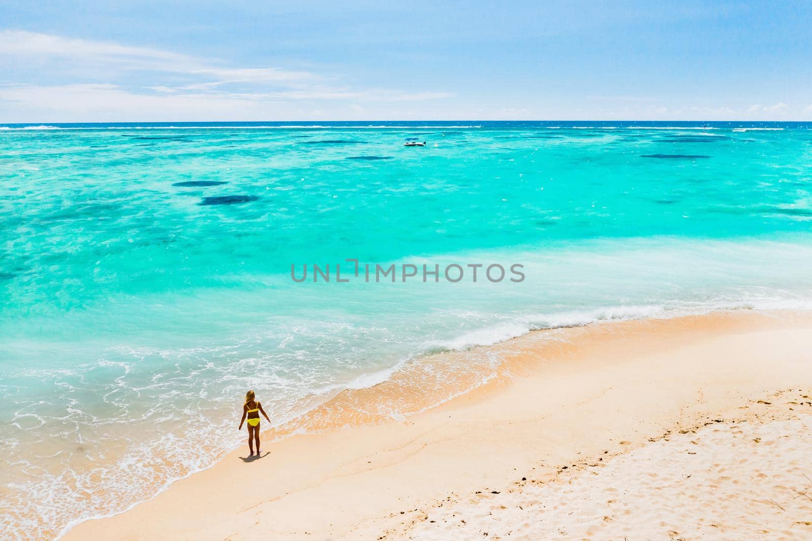 Mauritius, Indian Ocean - portrait of a girl walking along the beach with tourists from all over the world visiting the paradise island of Mauritius. by Lobachad