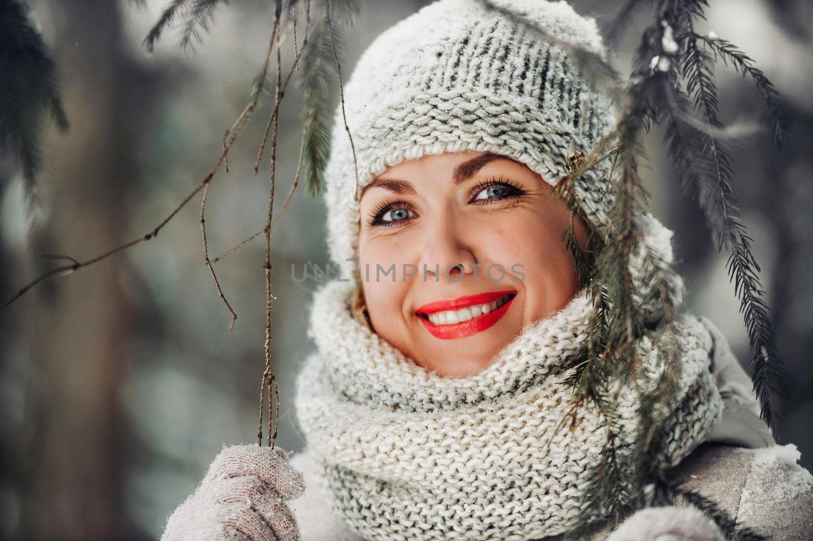 Portrait of a woman in gray clothes in a winter forest.Girl in the new year's snow-covered forest. by Lobachad