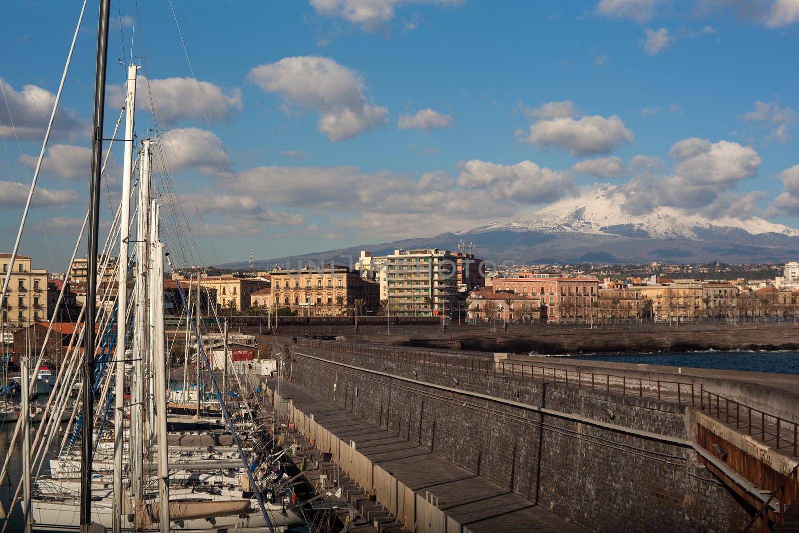 View of Catania from harbor, Etna volcano on background, Sicily. Italy