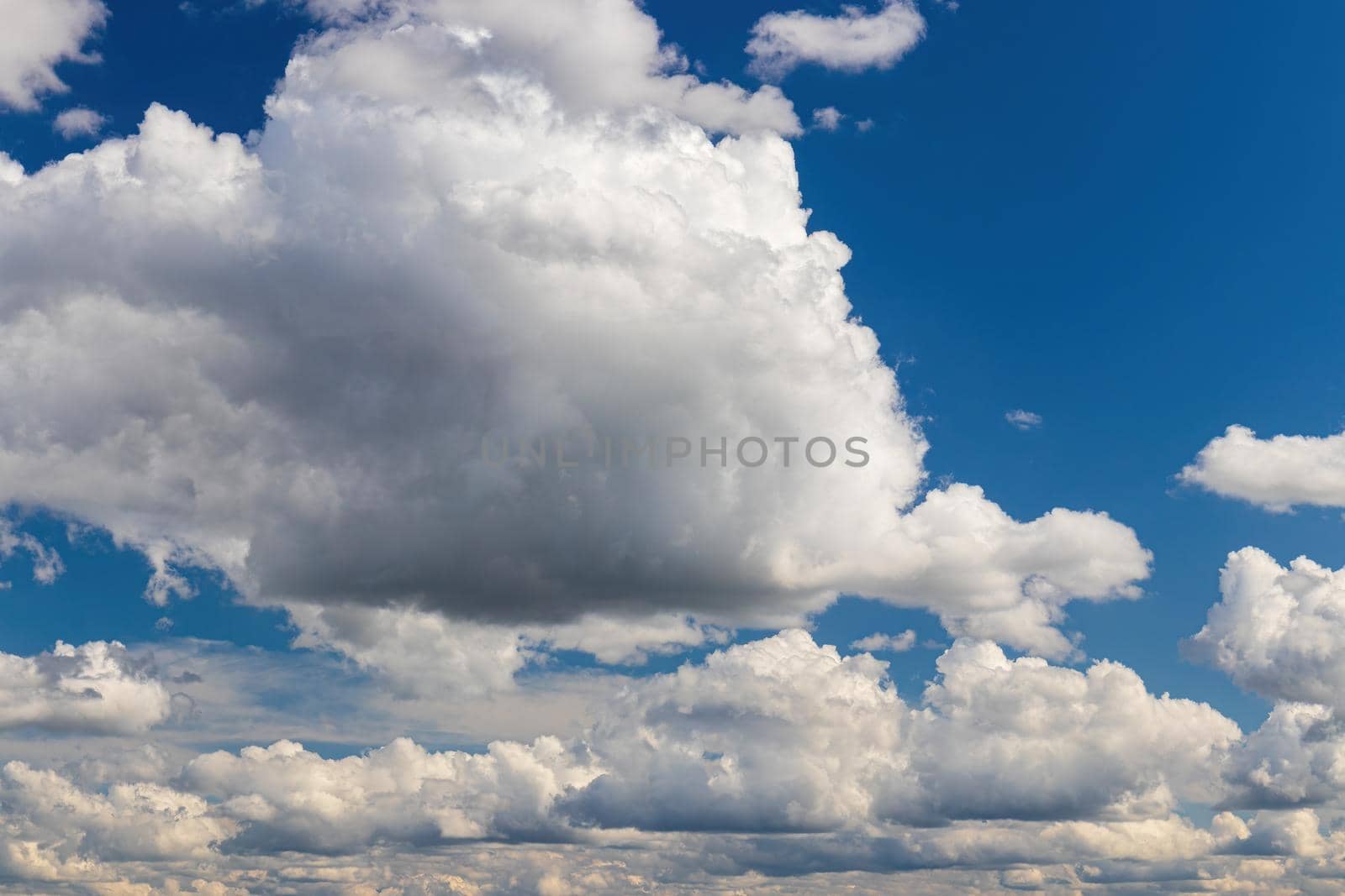 White cumulus fluffy clouds In a blue sky. Background from clouds.