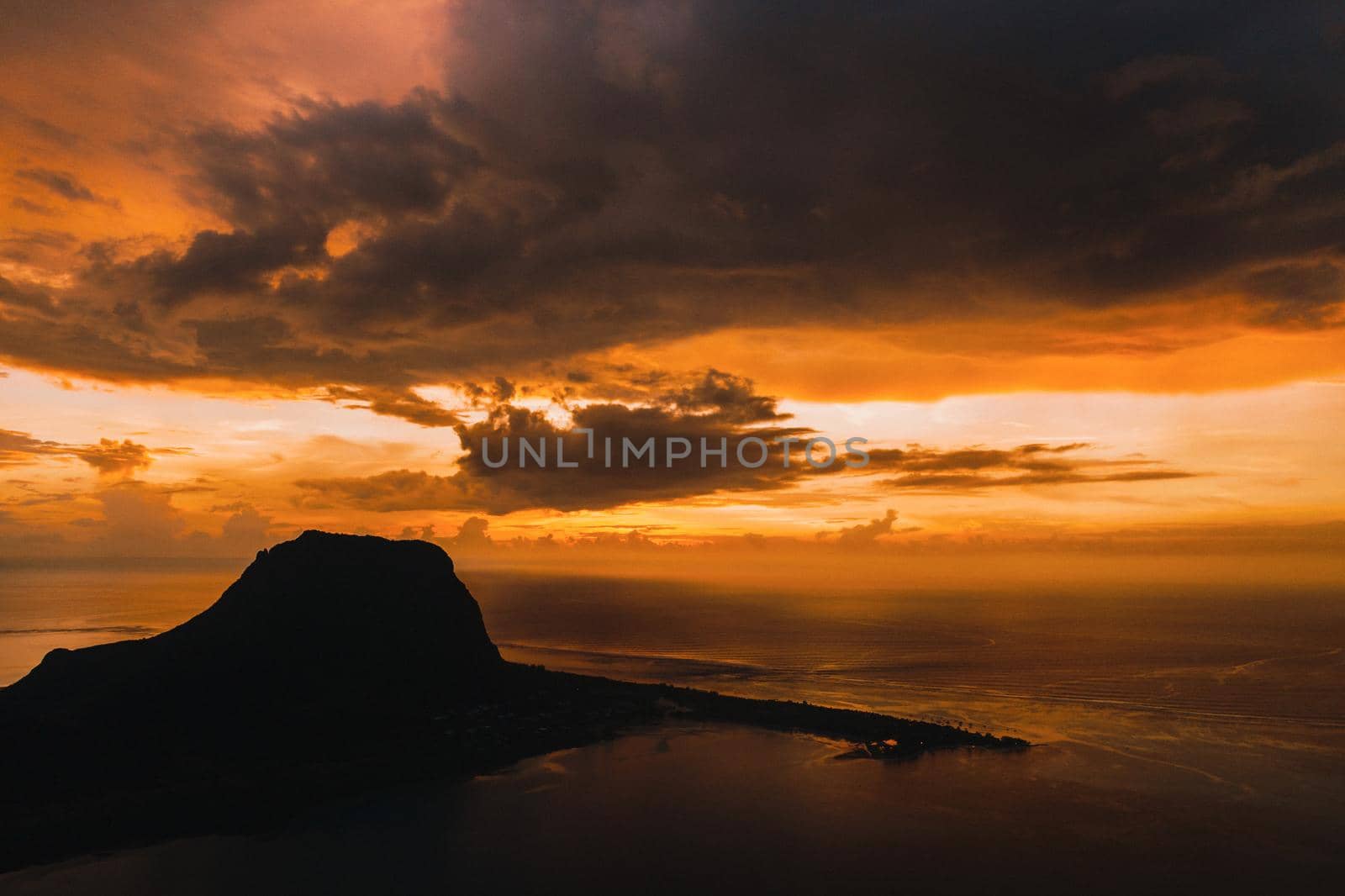 Aerial view with ocean at warm sunset time and Le Morn mountain in Mauritius