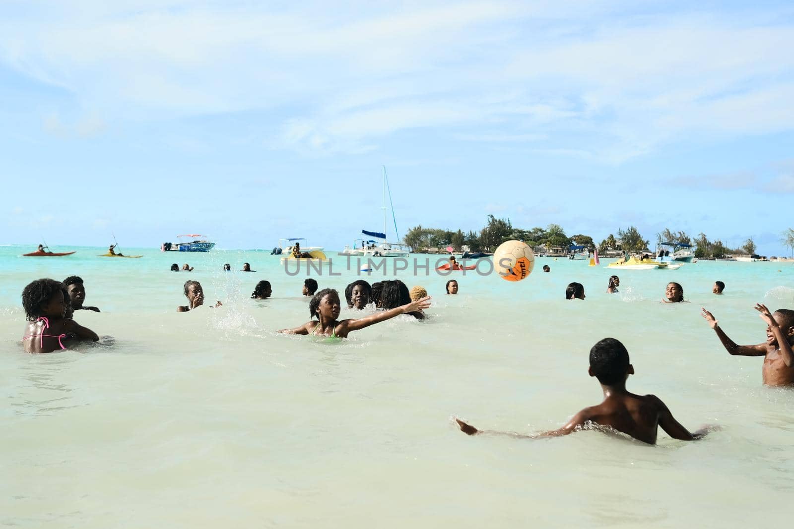 December 8, 2019 Mauritius Island, locals swim in the Indian Ocean and play with a ball.