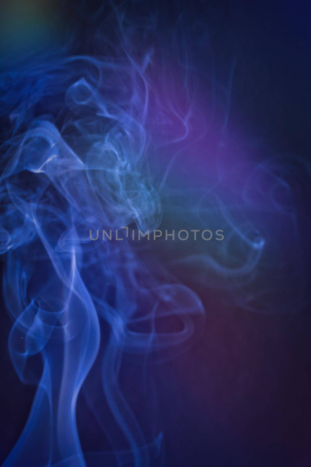 A vertical shot of smoke in colorfull backlight with a blue note