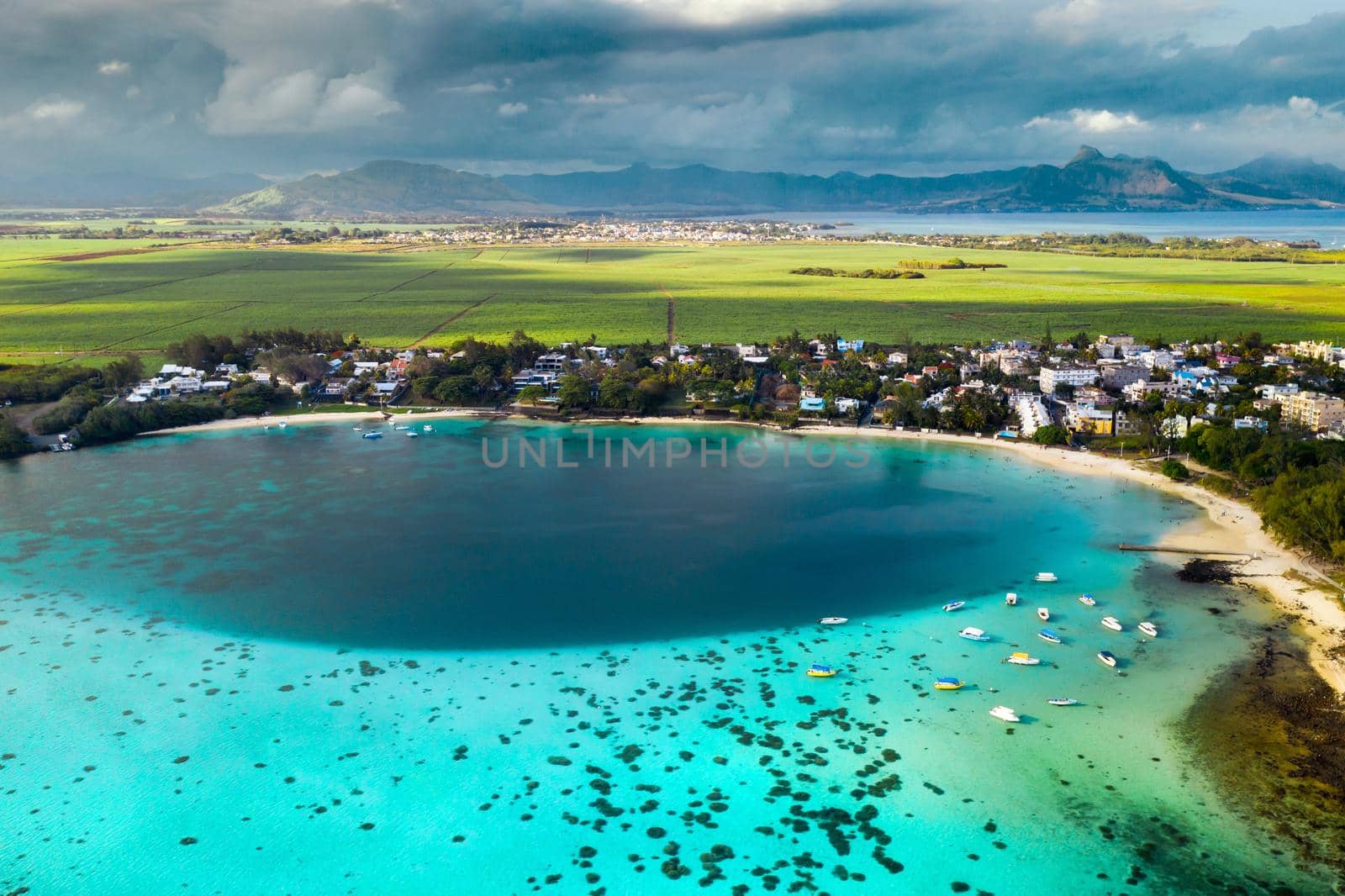 Top view of the Blue Bay lagoon of Mauritius. A boat floats on a turquoise lagoon.