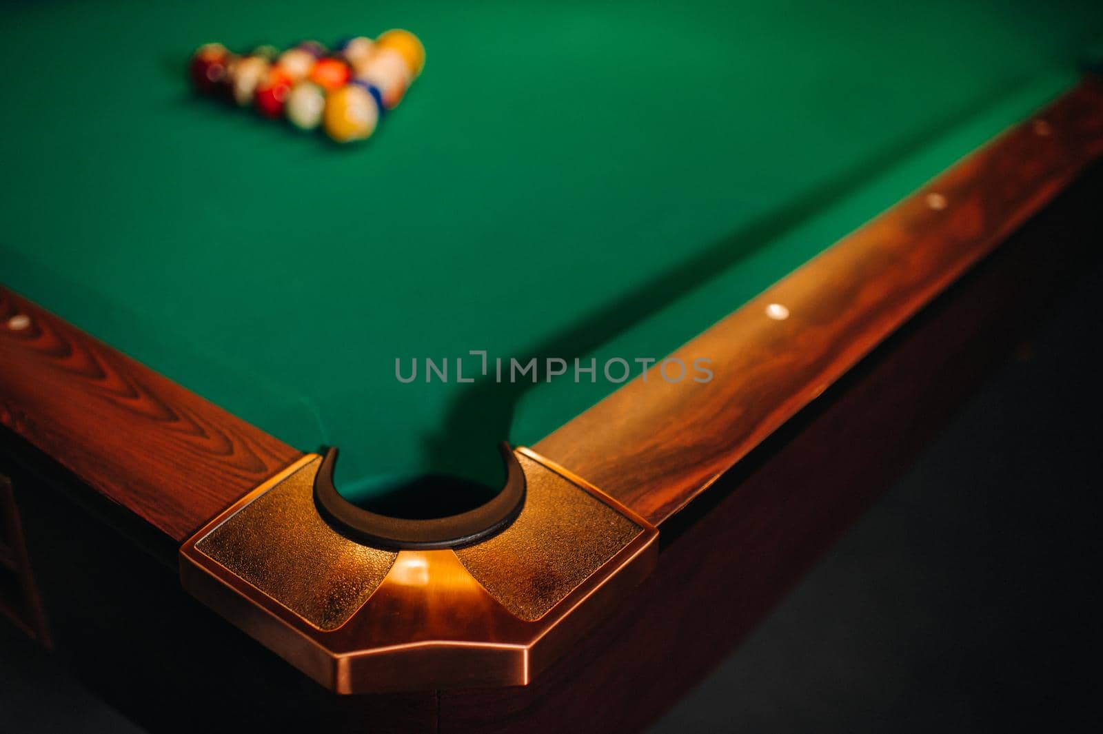 decorative billiard hole and green table with balls in the billiard club.
