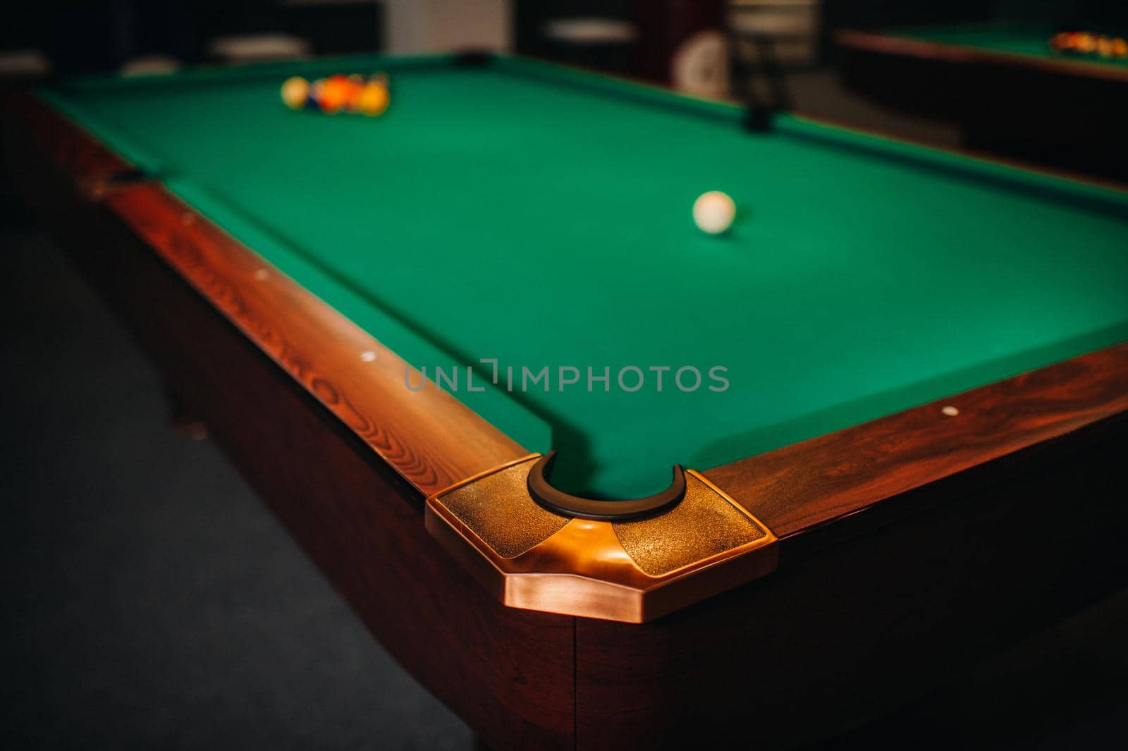 decorative billiard hole and green table with balls in the billiard club.