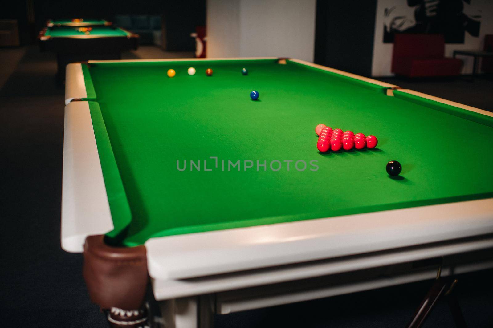 placing snooker balls on a green billiard table.